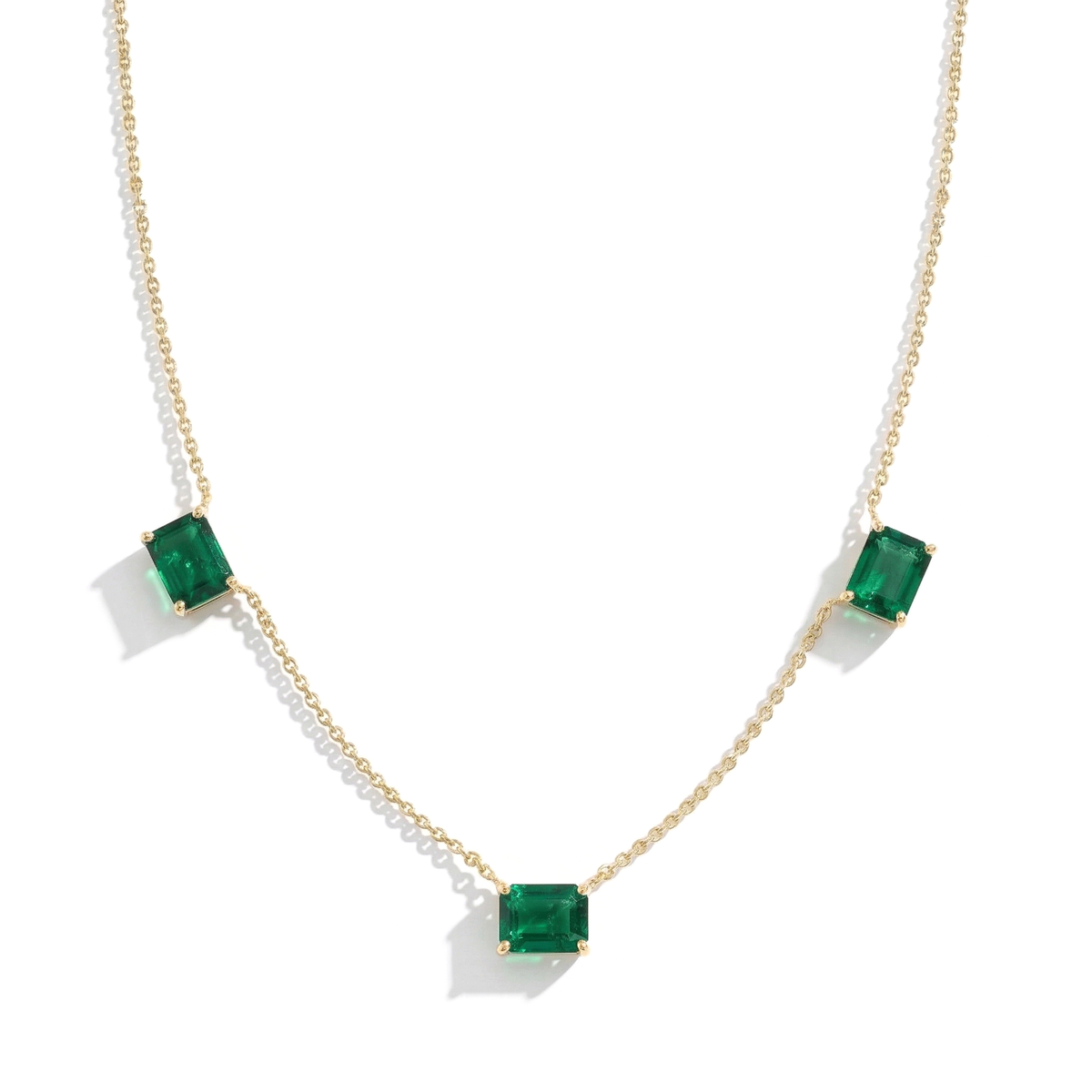 Three stone Emerald necklace featuring vibrant green gemstones.