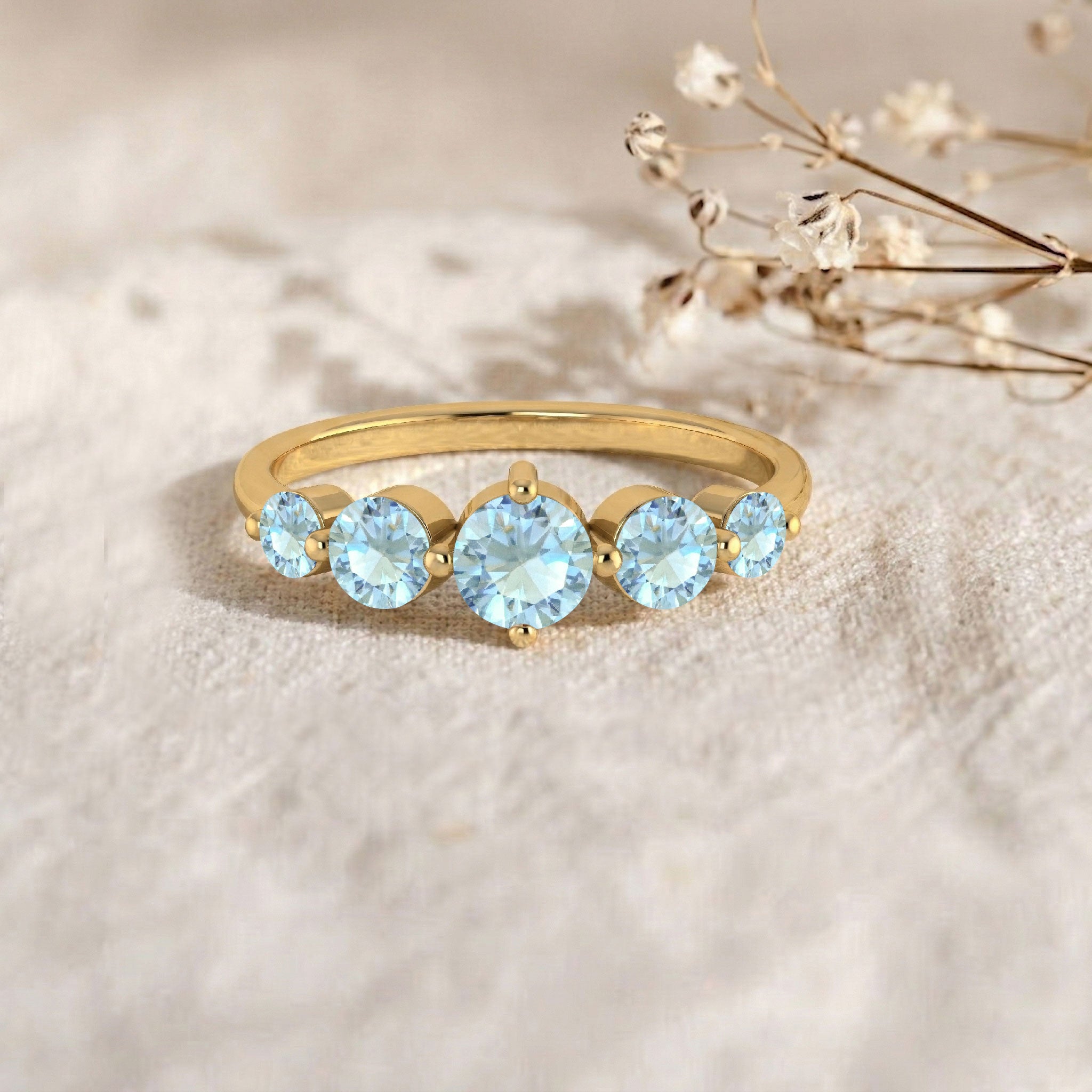 round aquamarine gemstone ring, five stone anniversary band, sterling silver jewelry, yellow gold filled jewelry, artisan handcrafted ring, brilliant blue gemstones, polished metal finish, elegant stacking ring, women's luxury accessory, sophisticated fashion jewelry, sparkling gemstone brilliance, meaningful gift ring, classic jewelry style, comfortable band, refined elegance