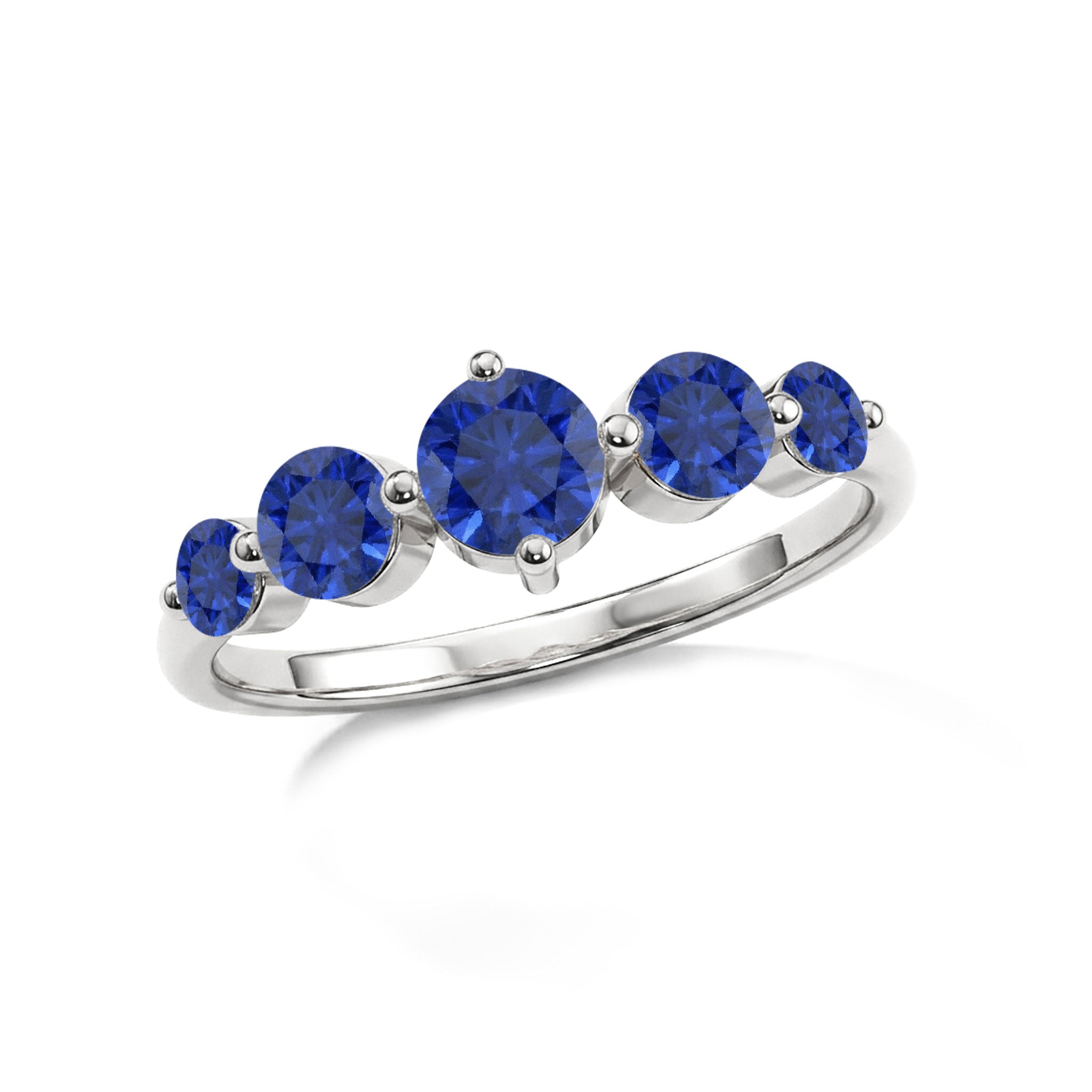 blue sapphire anniversary jewelry, fine gemstone ring, elegant everyday accessory, graduated stone setting, luxurious women's gift, handcrafted premium ring, royal blue brilliance, timeless jewelry piece, sparkling gemstone fashion, refined ring silhouette, stackable elegance, stylish sapphire jewelry, anniversary keepsake, polished luxury band, modern sophistication