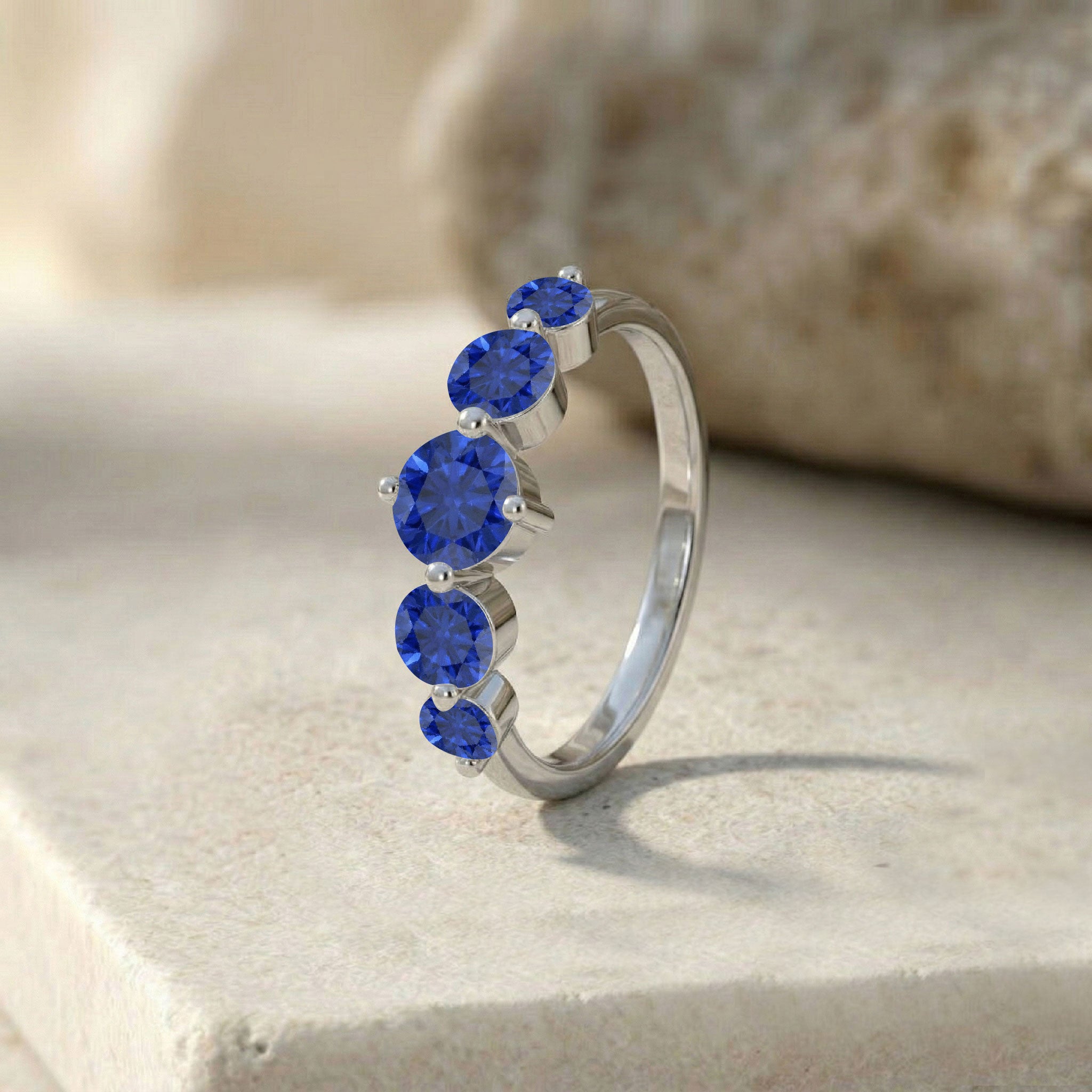 blue sapphire fashion ring, elegant gemstone band, luxurious women's jewelry, brilliant blue sparkle, minimalist fine jewelry, handcrafted sapphire accessory, refined anniversary ring, timeless stacking band, royal gemstone design, modern elegance, everyday luxury ring, classic jewelry gift, polished craftsmanship, premium ring, sophisticated styling
