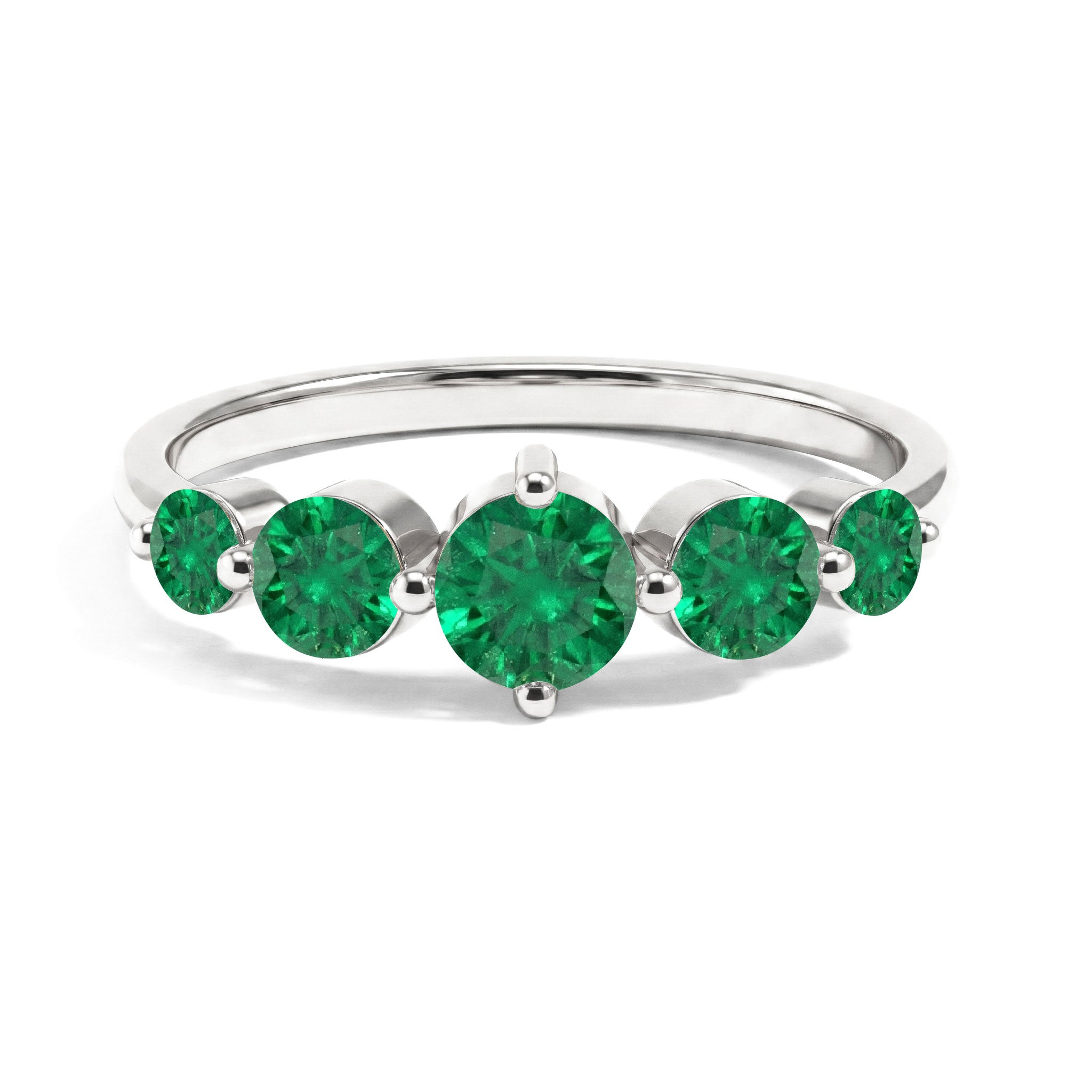 A silver five-stone ring featuring round brilliant-cut green emeralds, set in a polished silver band against a white background.