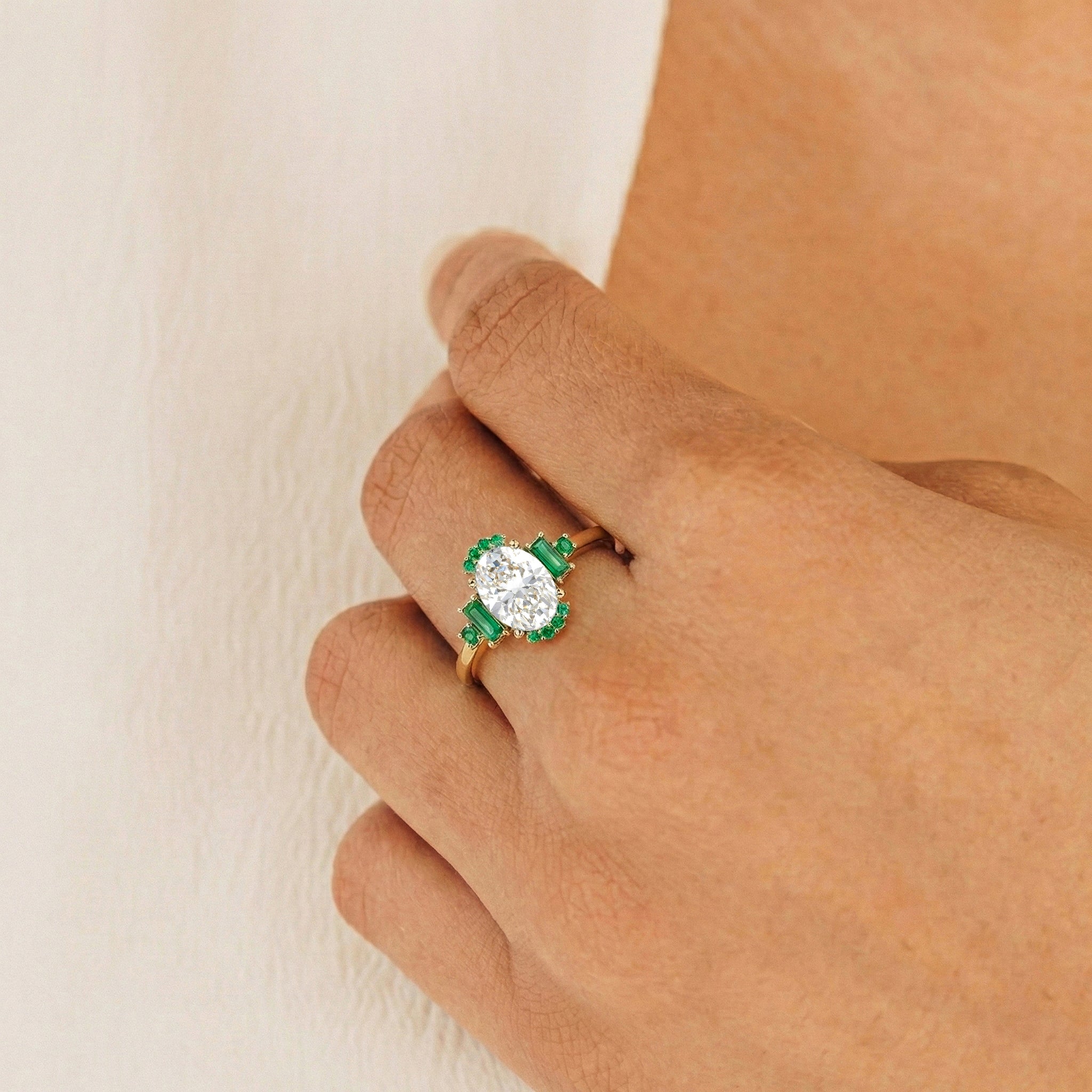 Close up view of oval emerald gemstone ring with cubic zirconia accents in sterling silver setting