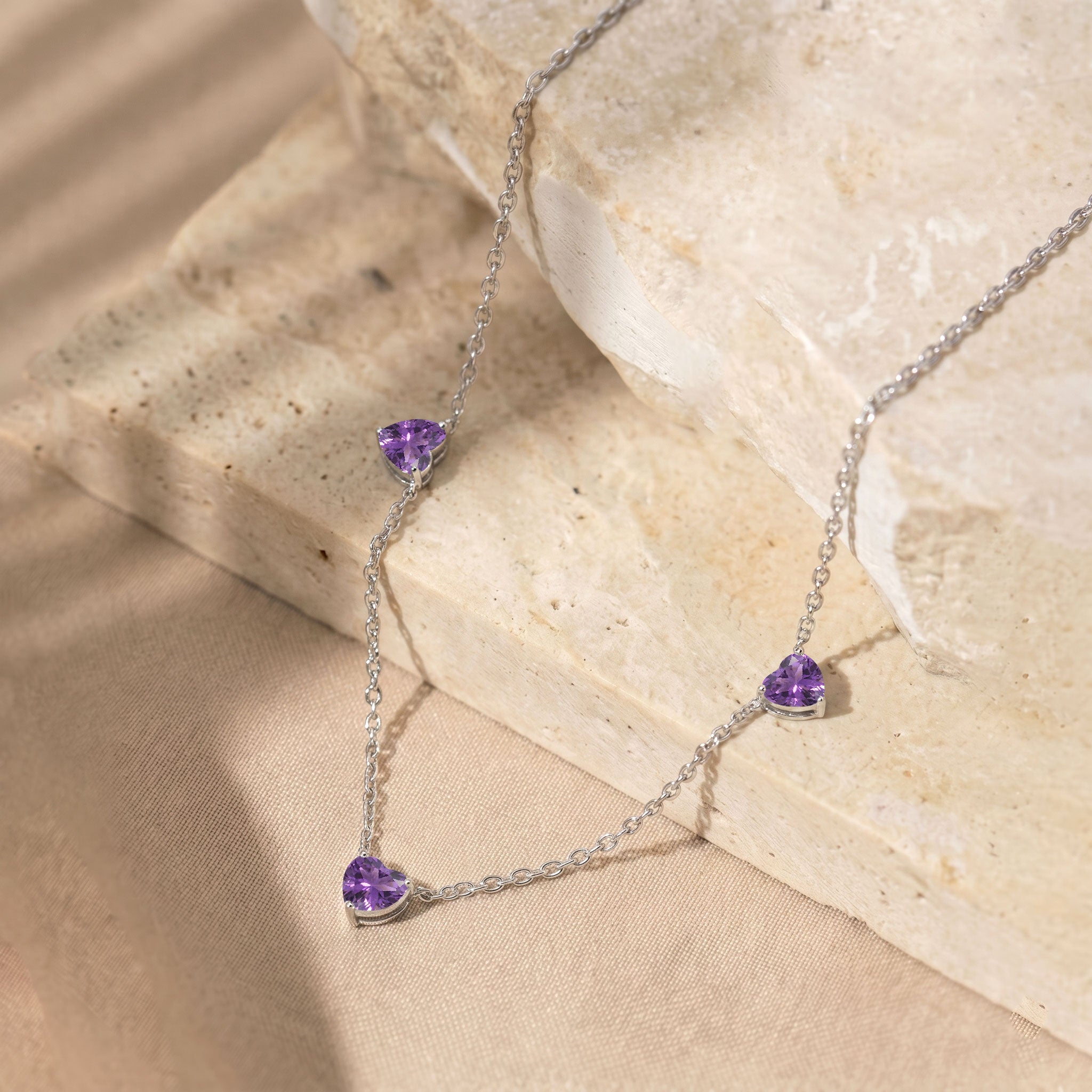 Genuine Natural Amethyst gemstone necklace with three heart-cut stones on a delicate chain.
