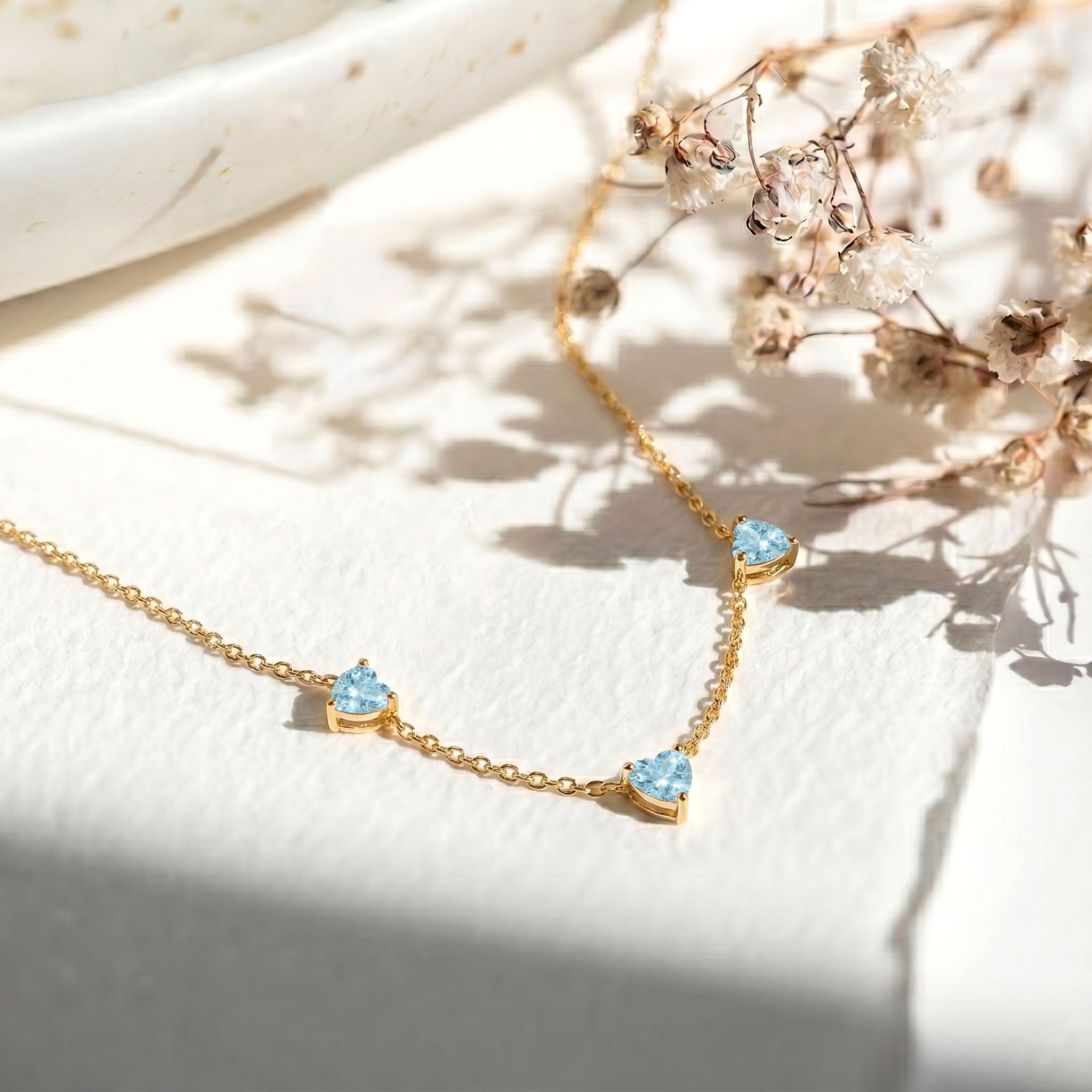 Fine jewelry Aquamarine necklace with three heart-shaped natural gemstones.
