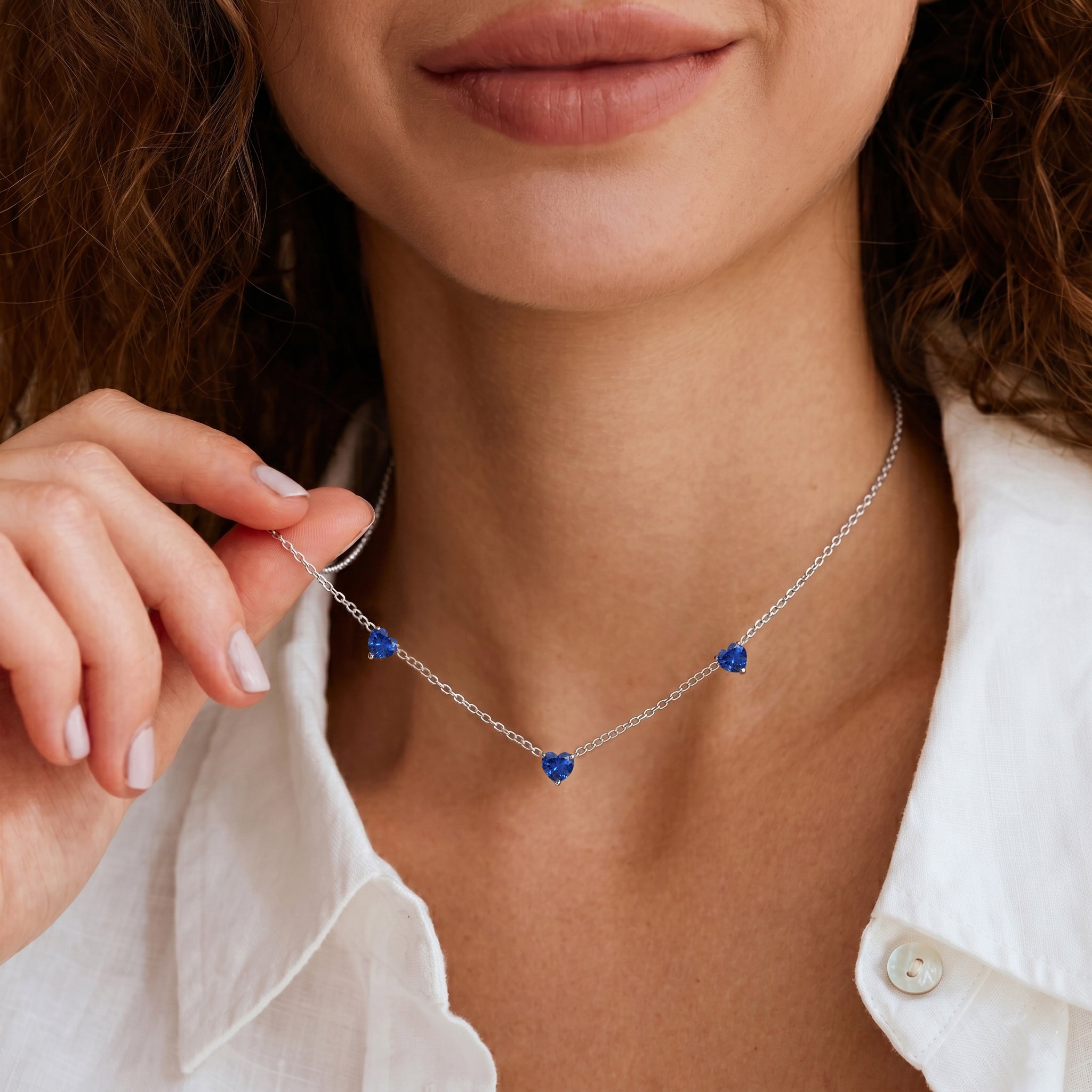 Elegant Blue Sapphire Three Stone Heart Necklace with genuine blue gemstones.
