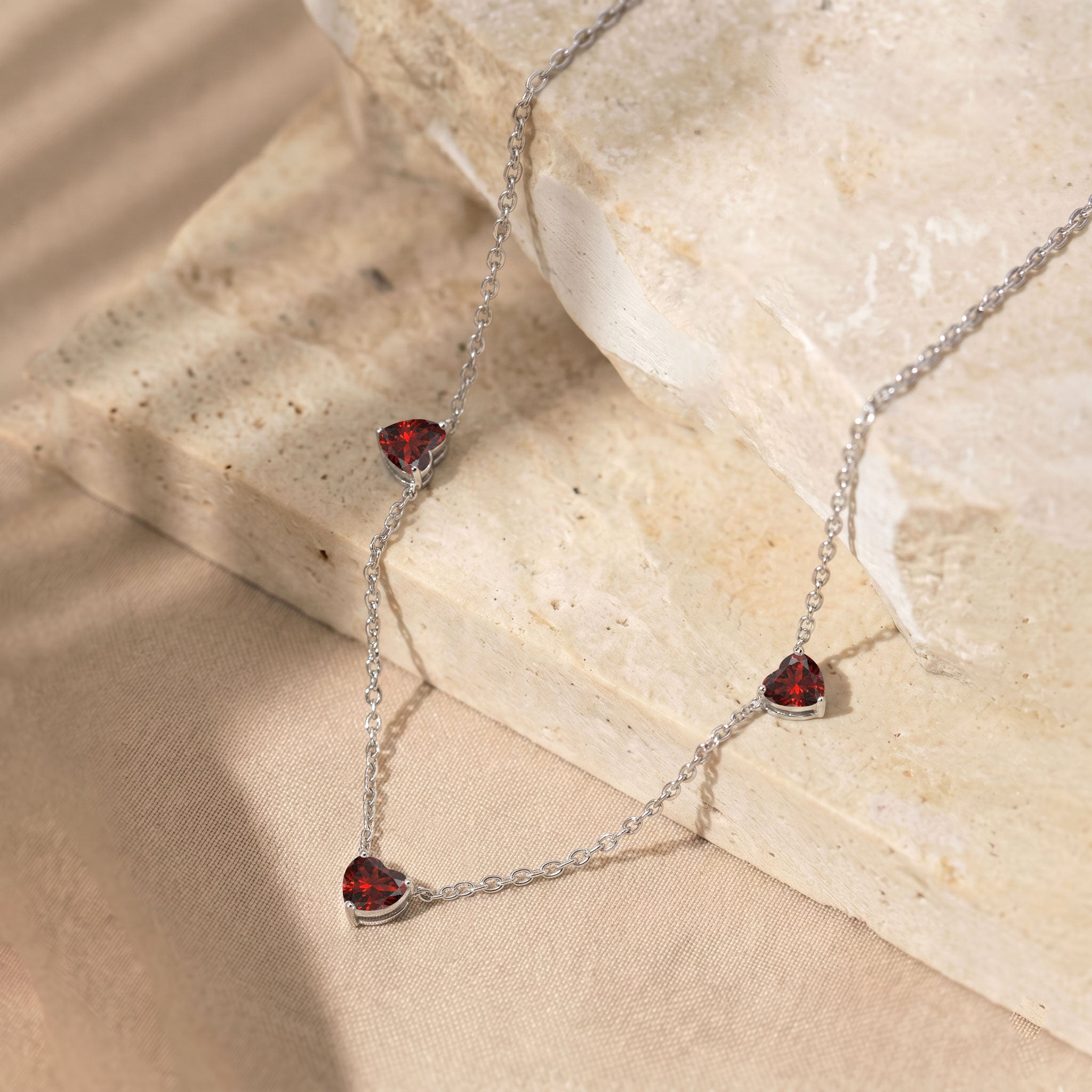 Elegant Natural Garnet Three Stone Heart Necklace with genuine red gemstones.
