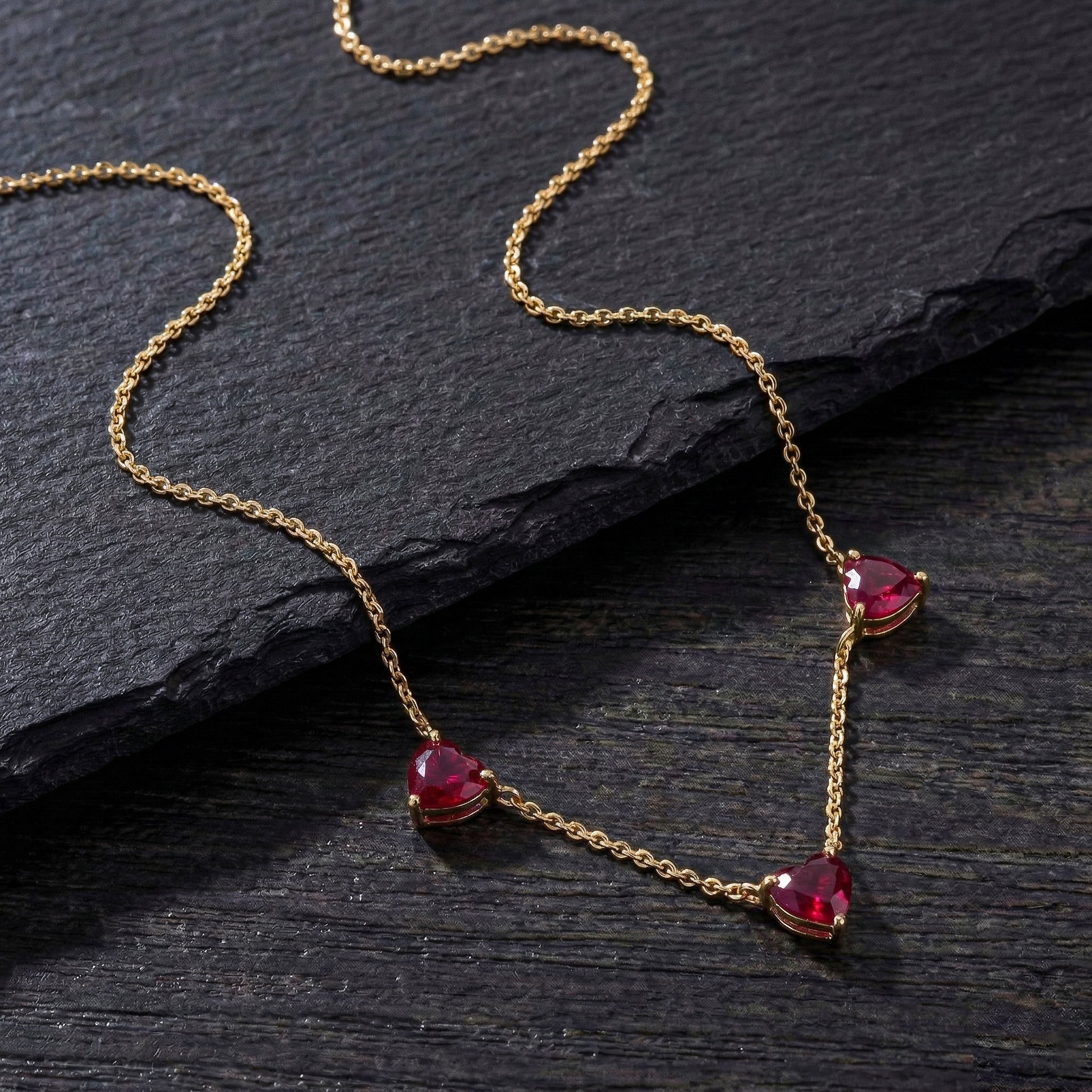 Genuine Ruby heart necklace featuring three 6mm heart-cut gemstones.
