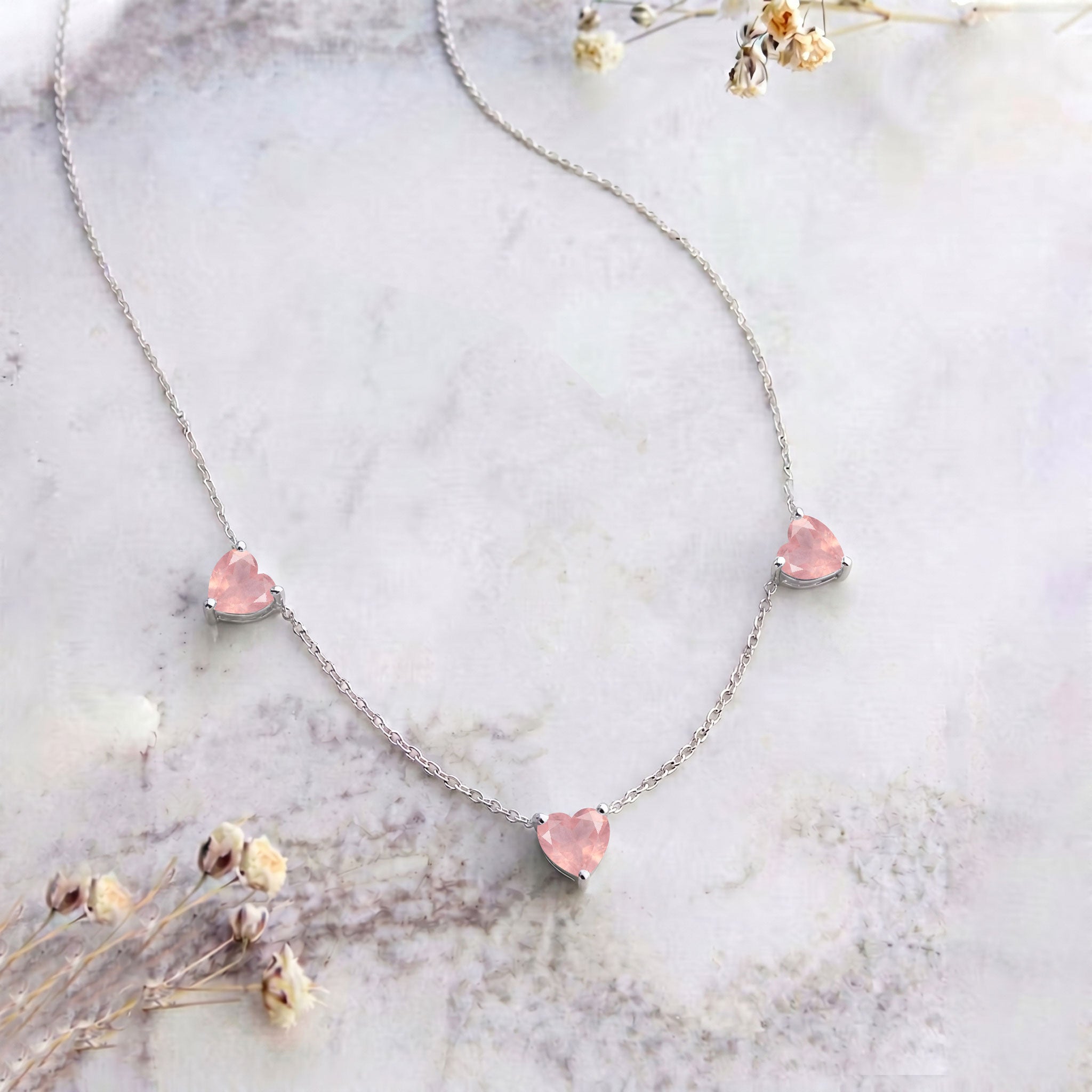 Elegant Natural Rose Quartz Three Stone Heart Necklace with soft pink gemstones.
