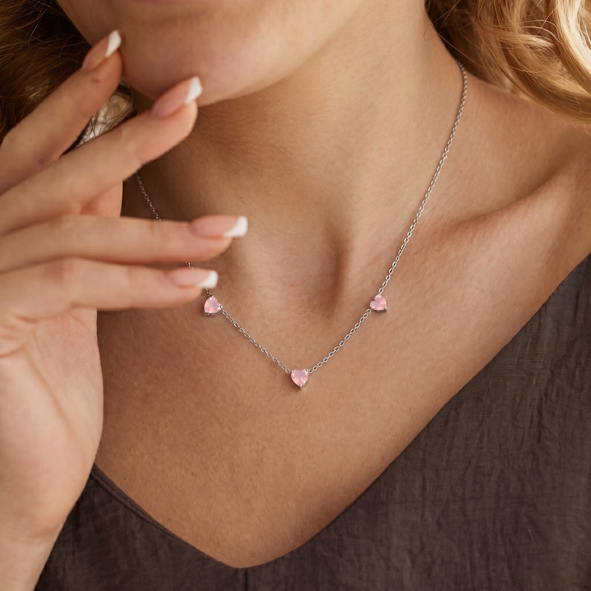Fine jewelry Natural Rose Quartz necklace with three heart-shaped gemstones.
