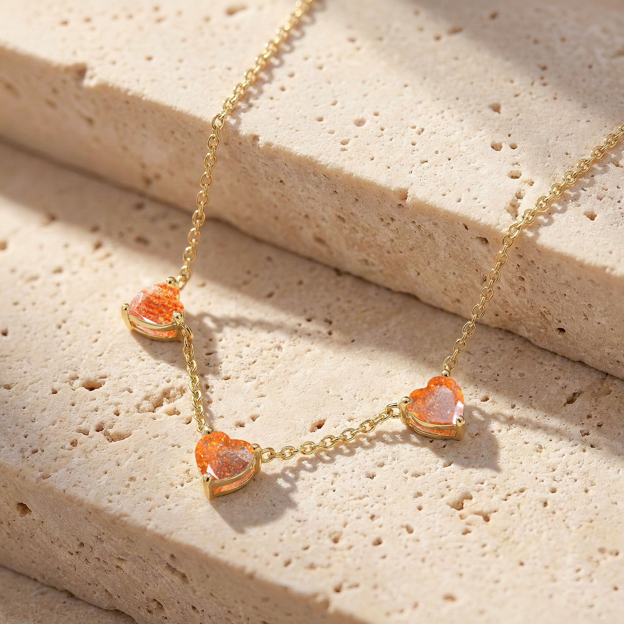 Dainty Sunstone Three Stone Heart Necklace featuring genuine 6mm heart gemstones.
