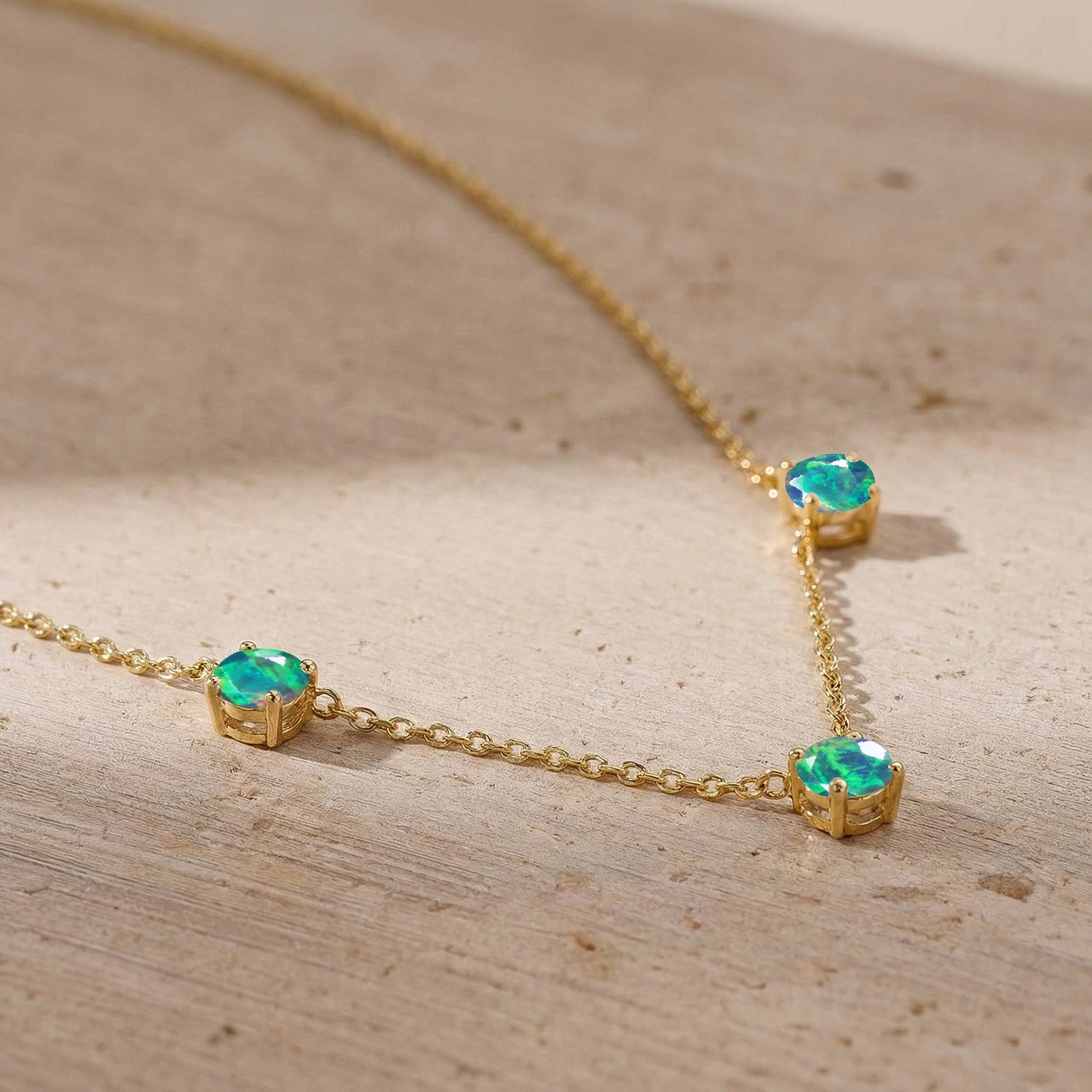 Fine jewelry Black Opal necklace with classic three stone station design.
