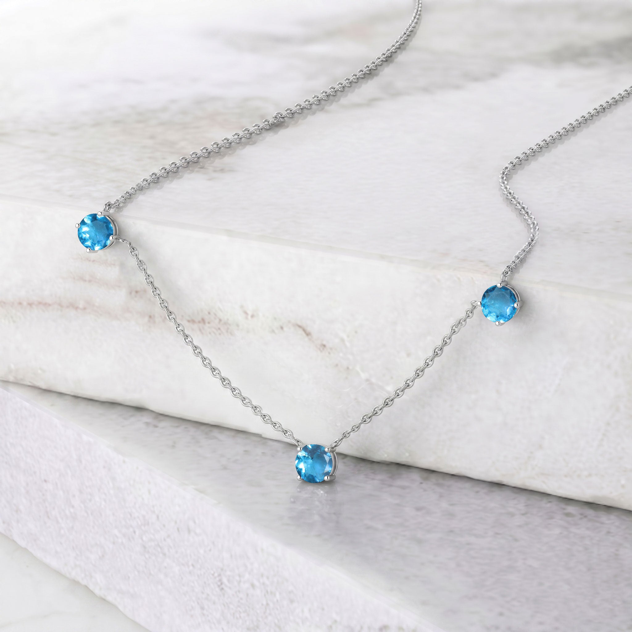 Beautiful December birthstone necklace showcasing sparkling blue topaz stones on a fine silver chain.
