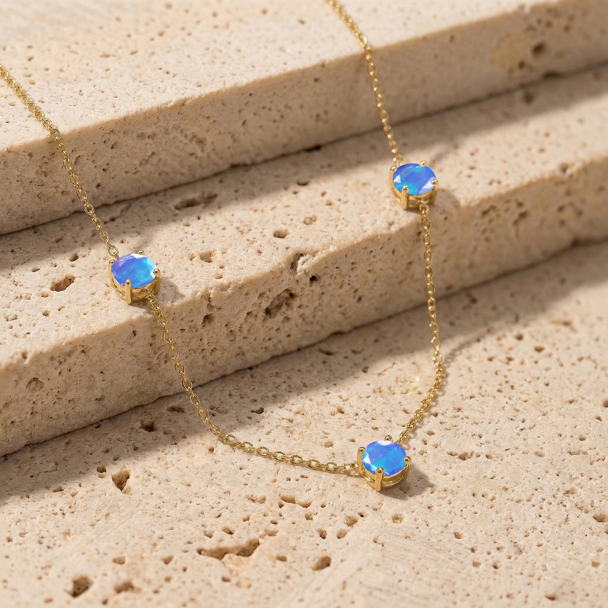 Fine jewelry Blue Opal necklace with classic three stone station design.
