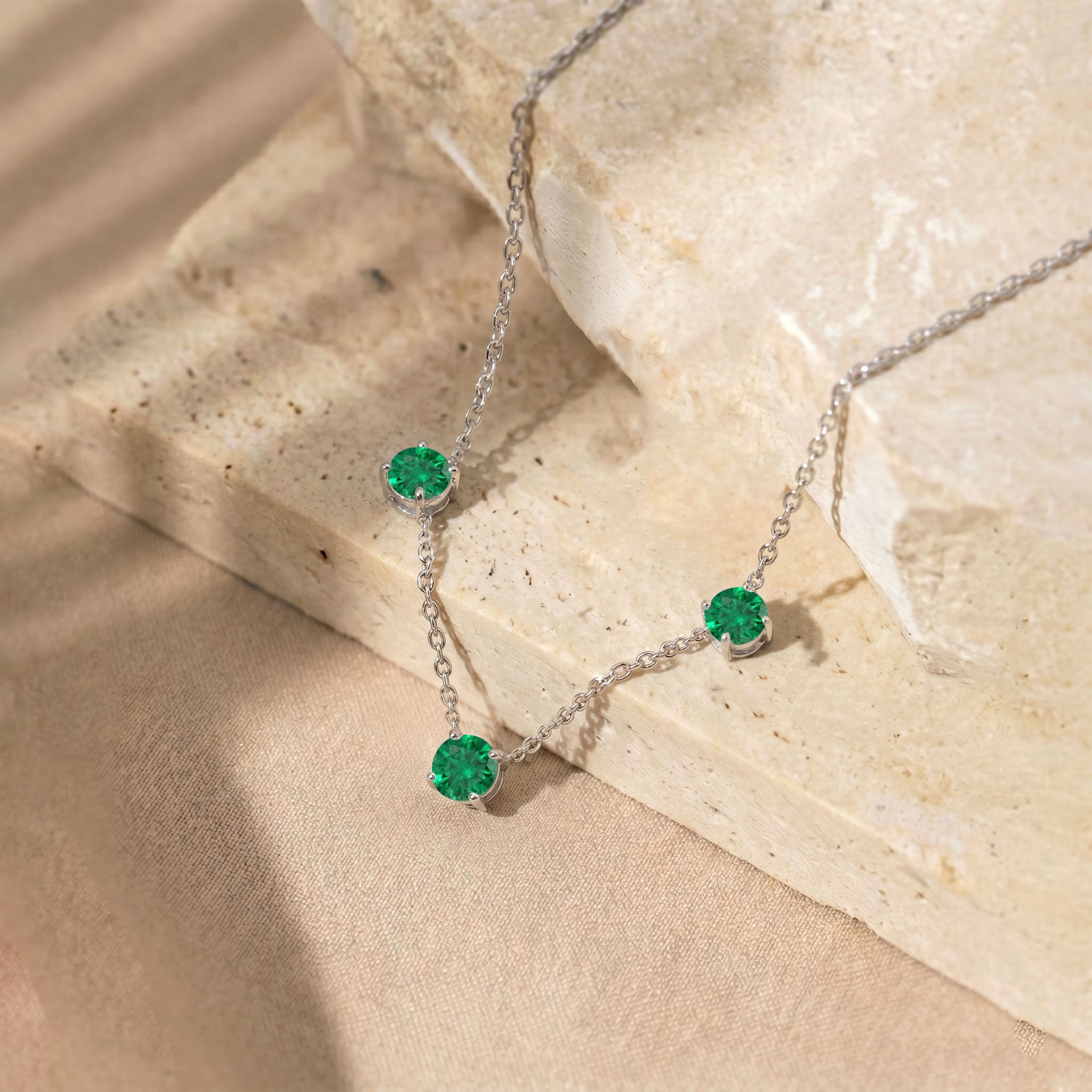 Three stone Emerald station necklace designed with a minimalist jewelry style.
