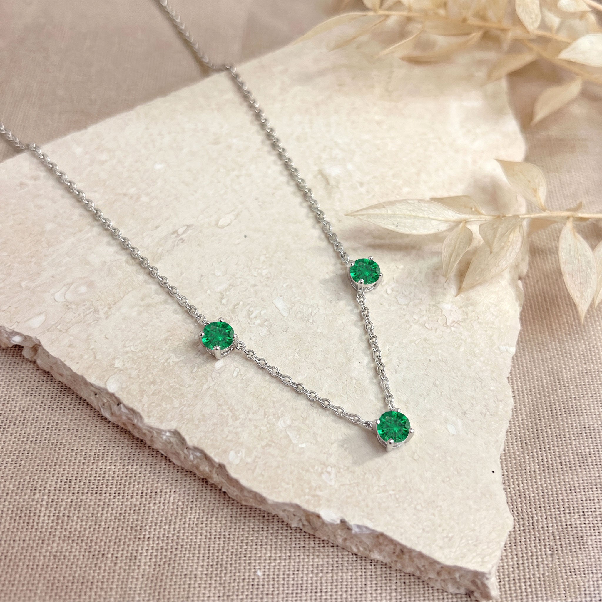 Fine jewelry Emerald necklace with classic three stone station design.
