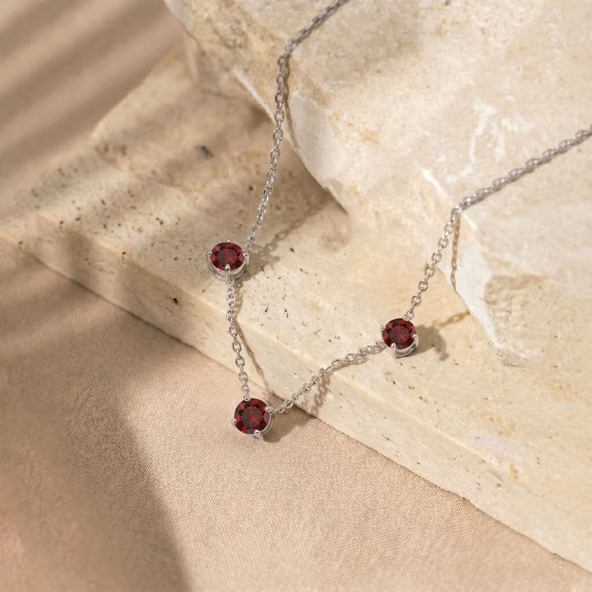 Three stone Garnet station necklace with a minimalist and timeless jewelry design.
