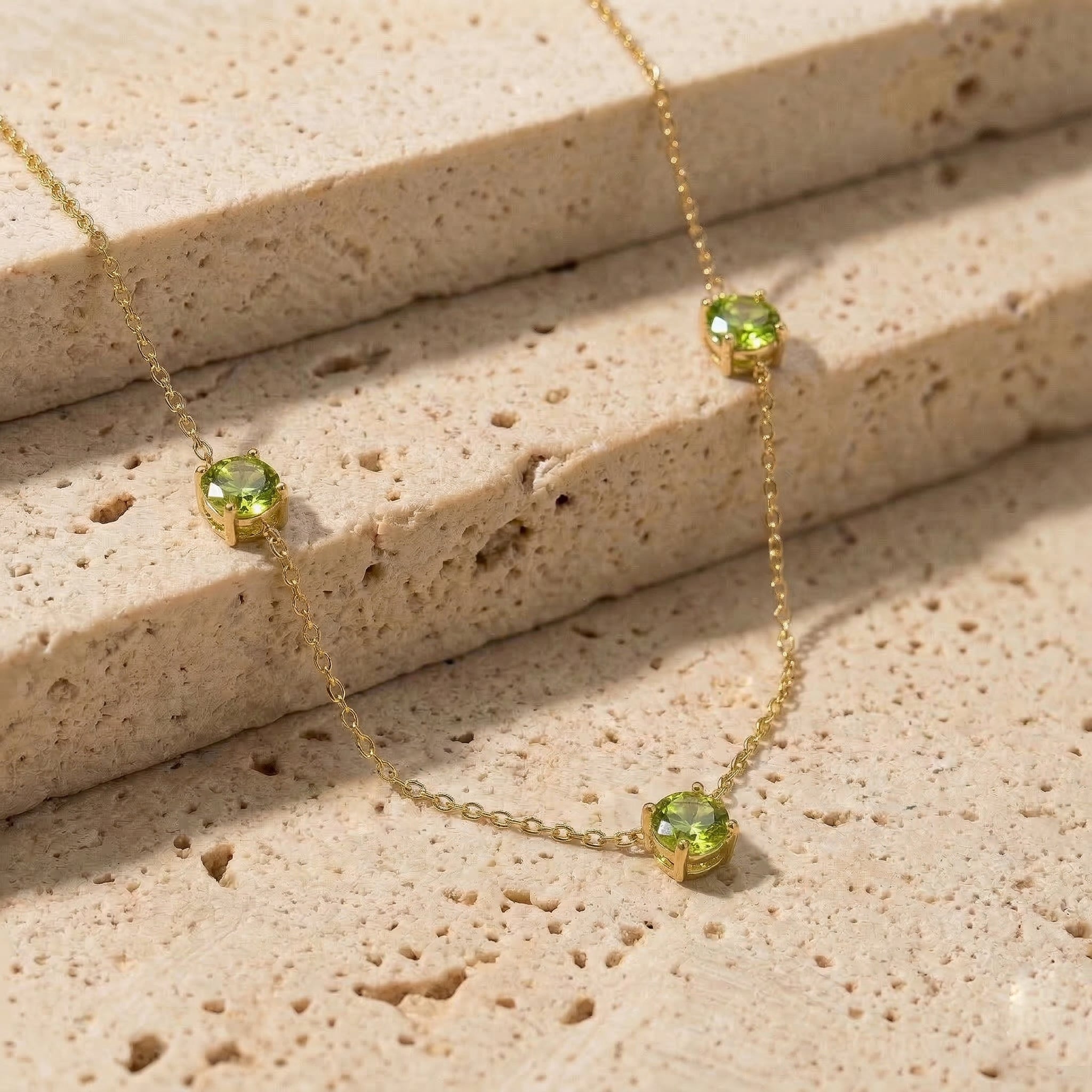 Fine jewelry Peridot necklace with classic three stone station design.
