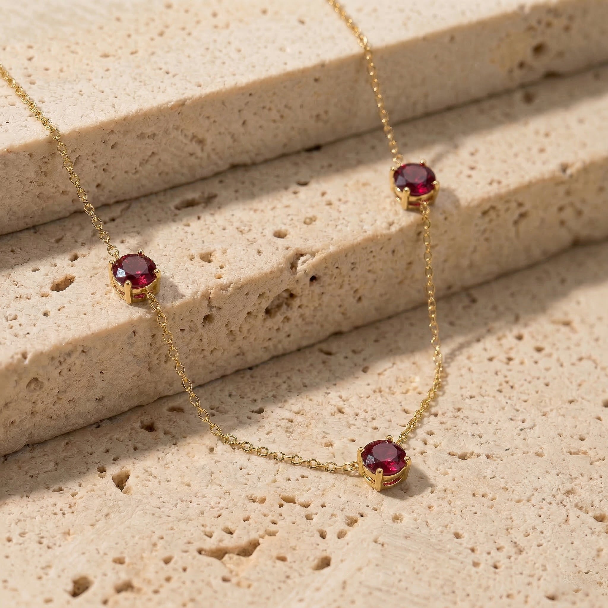 Fine jewelry Ruby necklace with classic three stone station design.
