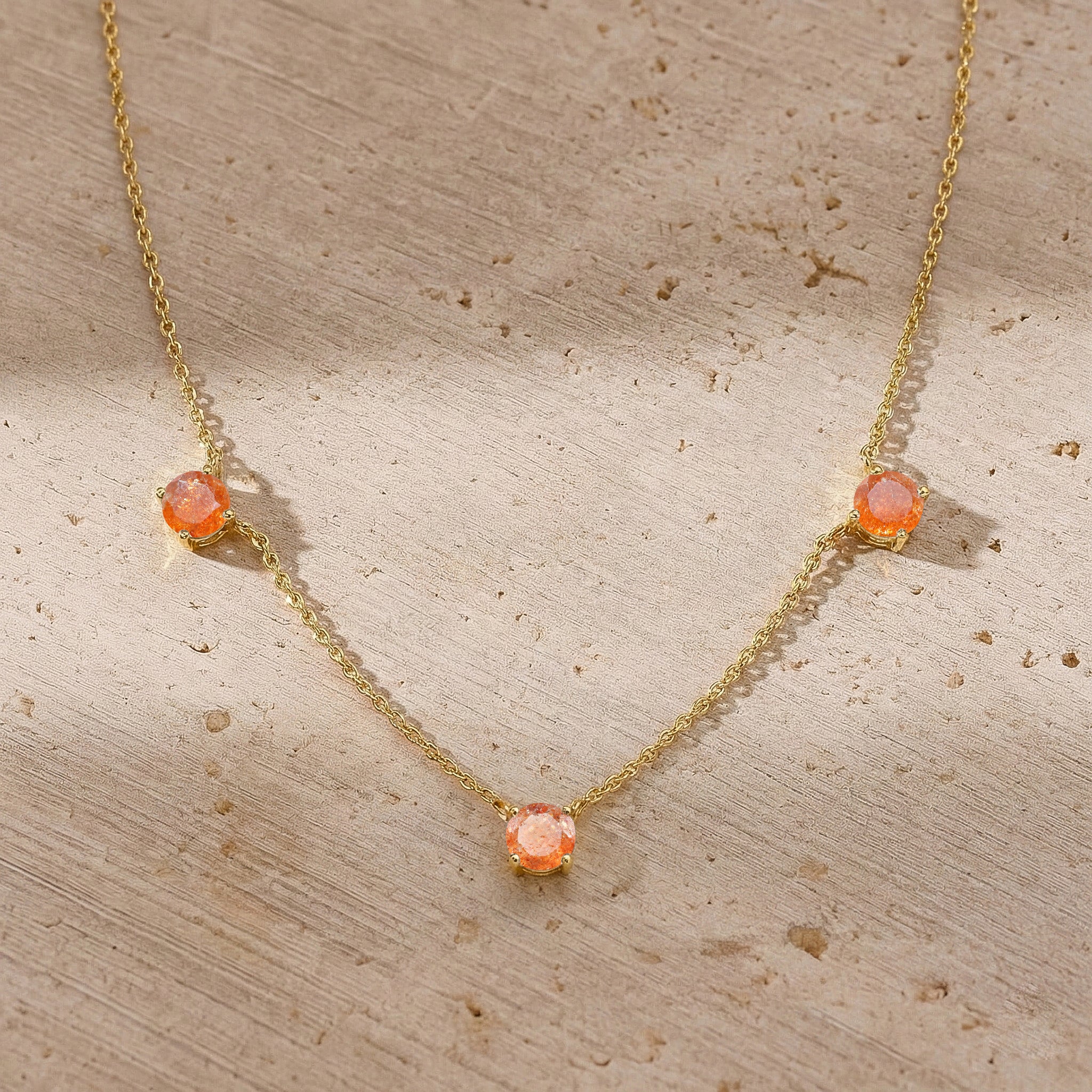 Fine jewelry Sunstone necklace with classic three stone station design.
