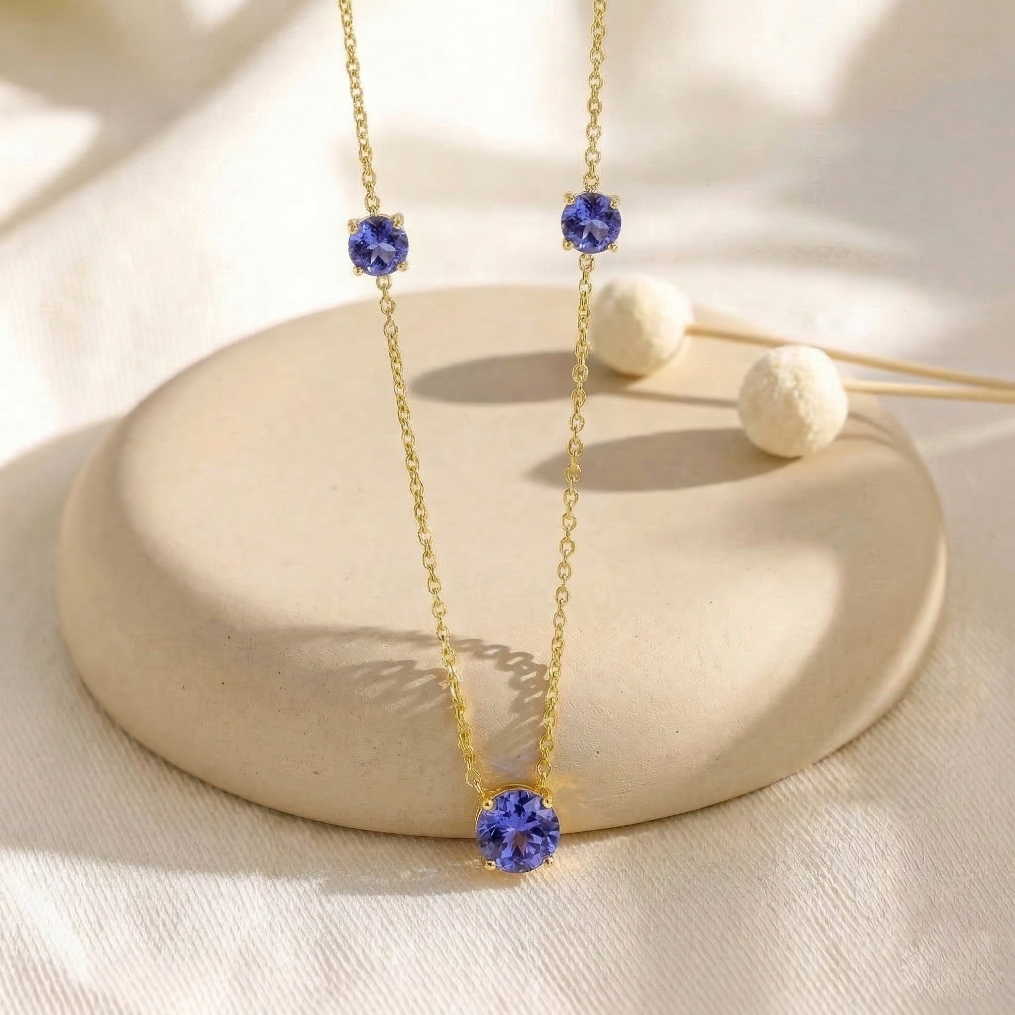 Fine jewelry Tanzanite necklace with classic three stone station design.
