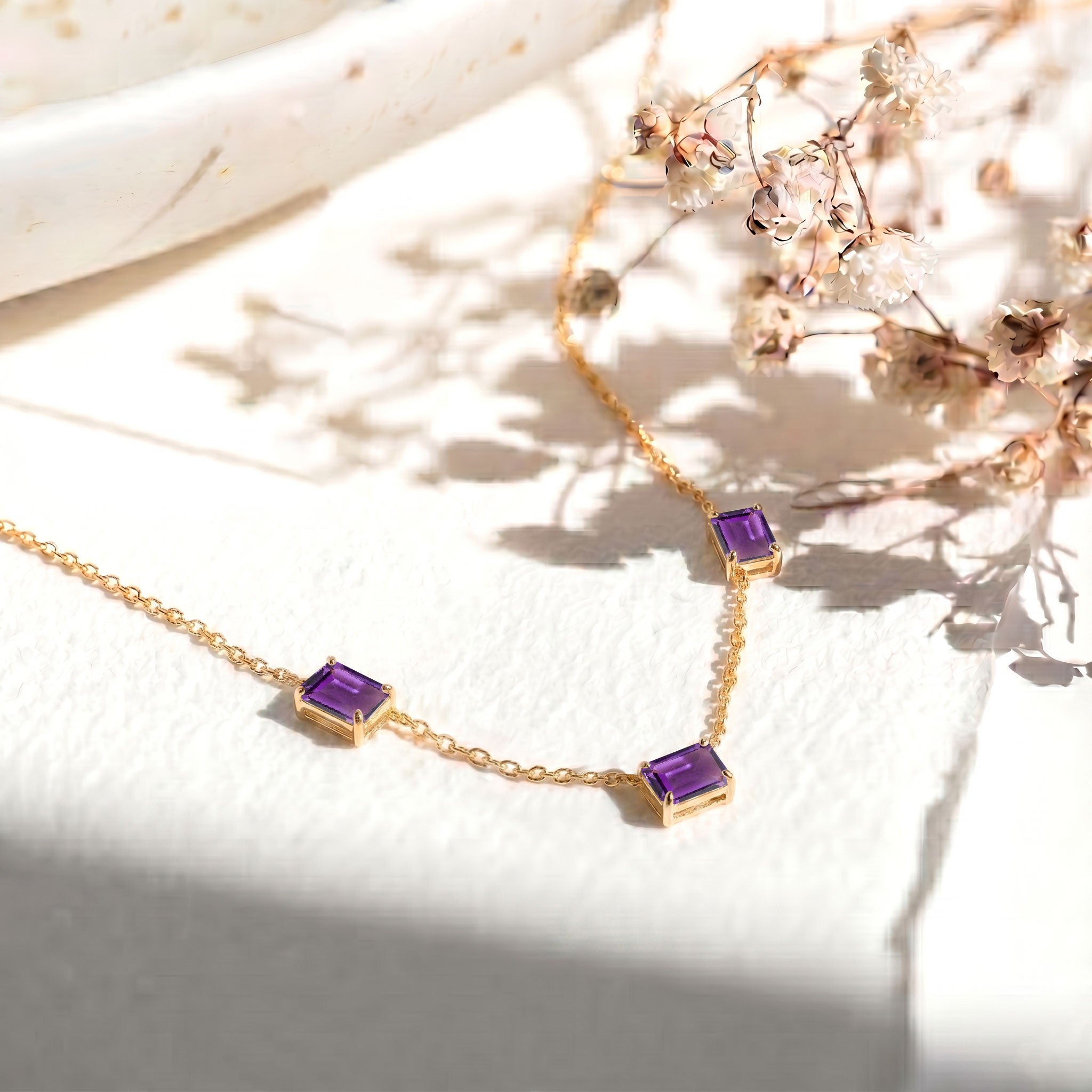 Three stone Amethyst necklace featuring vibrant purple octagon gemstones.
