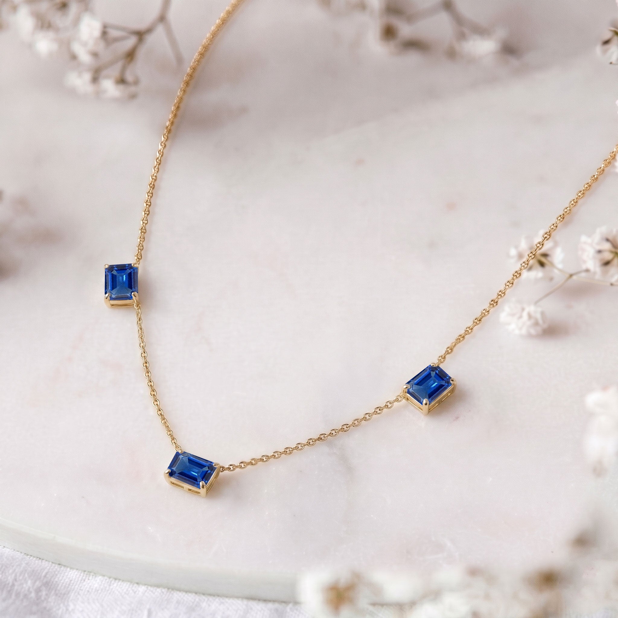 Fine jewelry Blue Sapphire station necklace with three octagon-cut gemstones.
