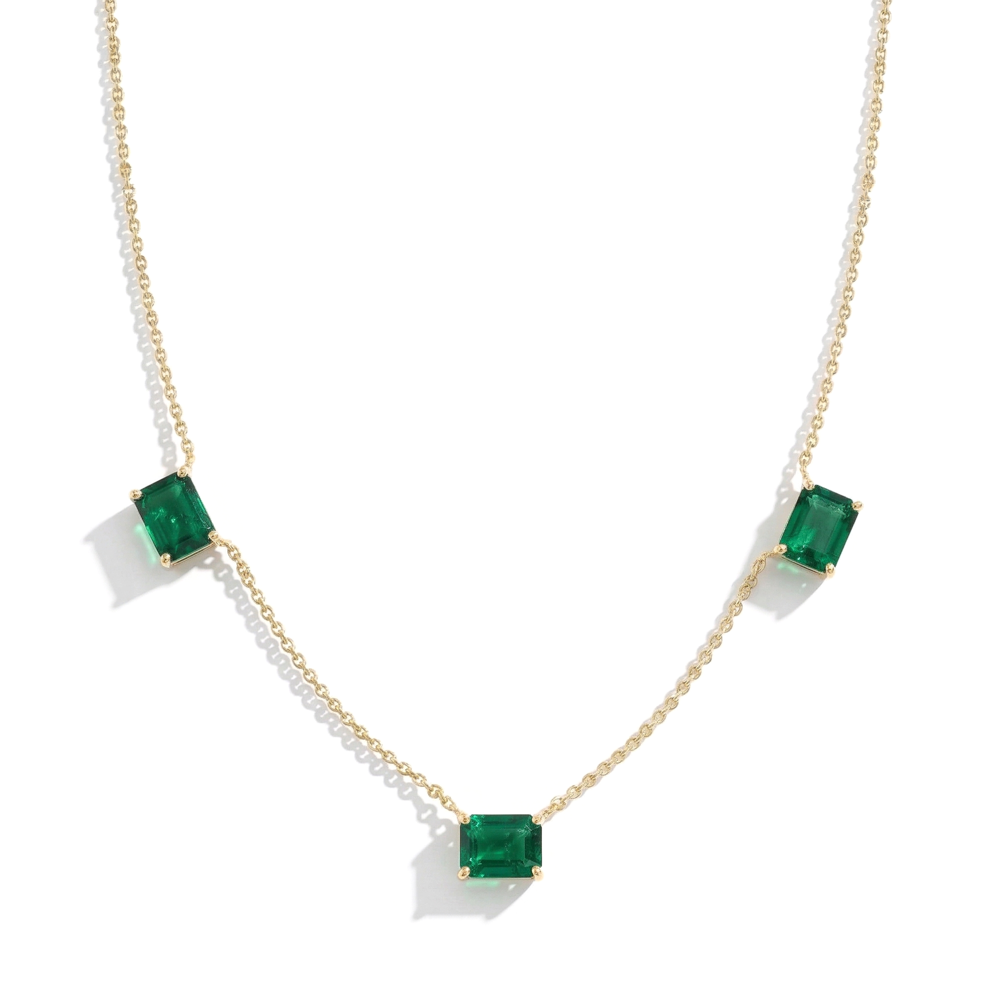 Three stone Emerald necklace featuring vibrant green gemstones.
