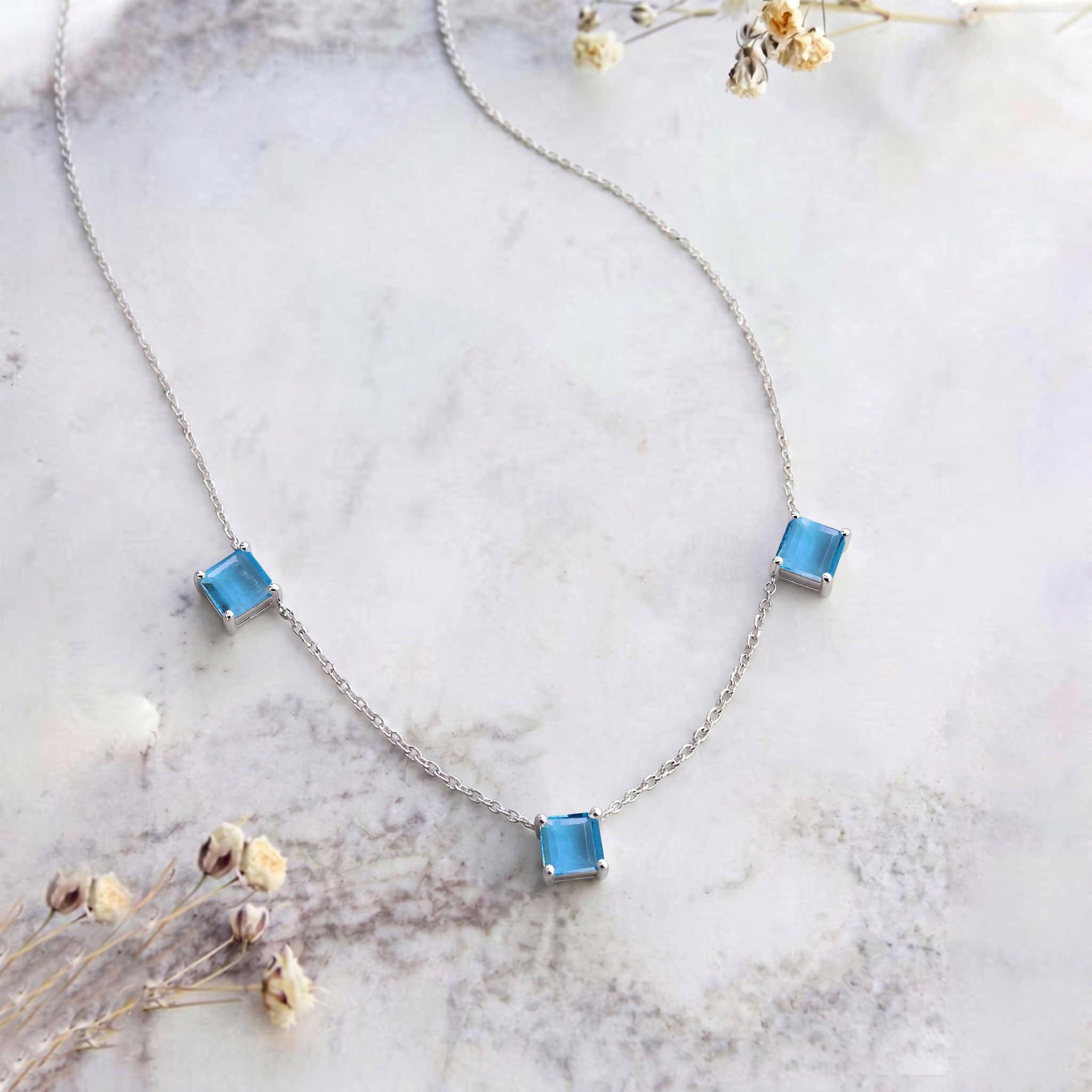 Three stone Blue Topaz necklace crafted in 925 sterling silver.

