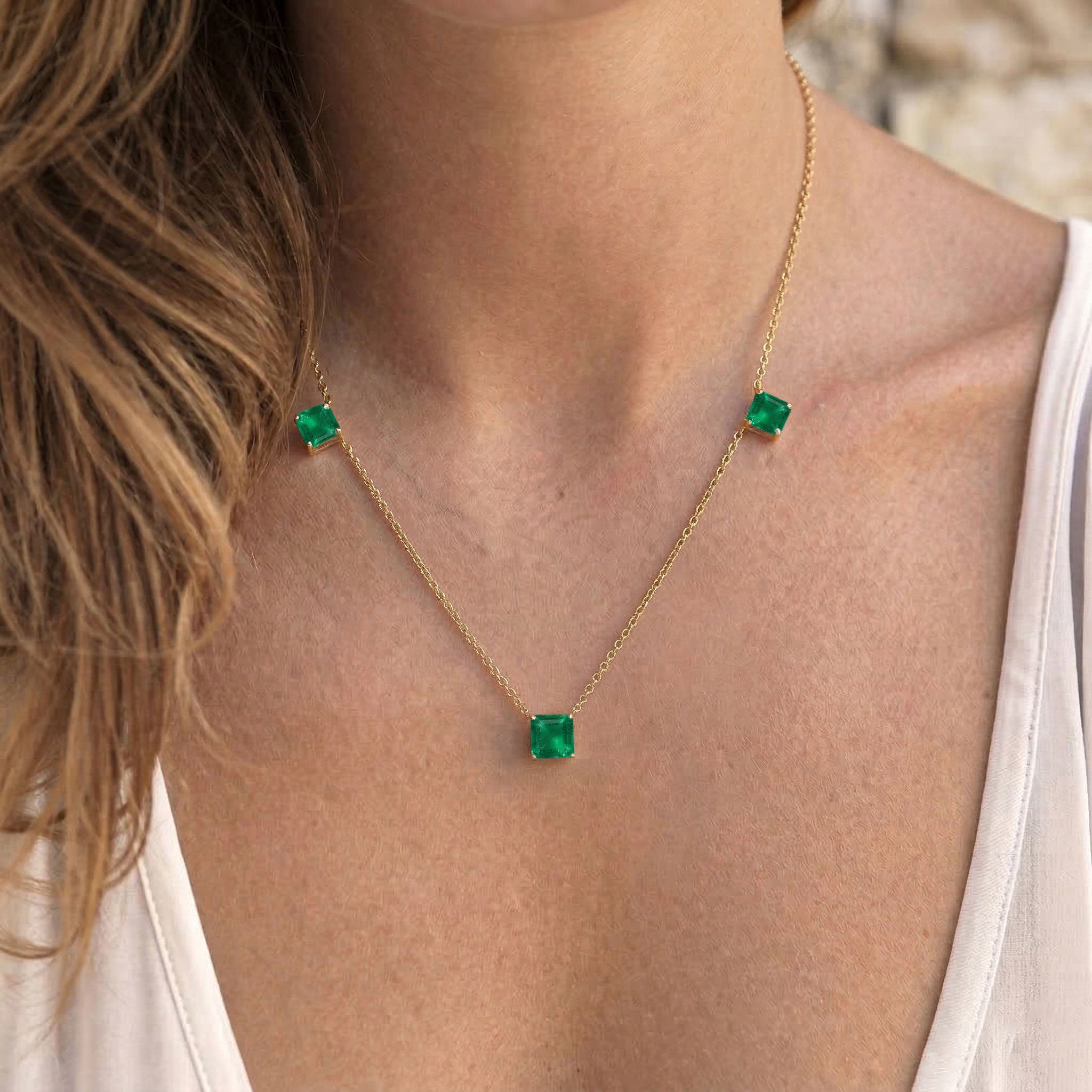 Contemporary Emerald necklace with minimalist three stone station design.
