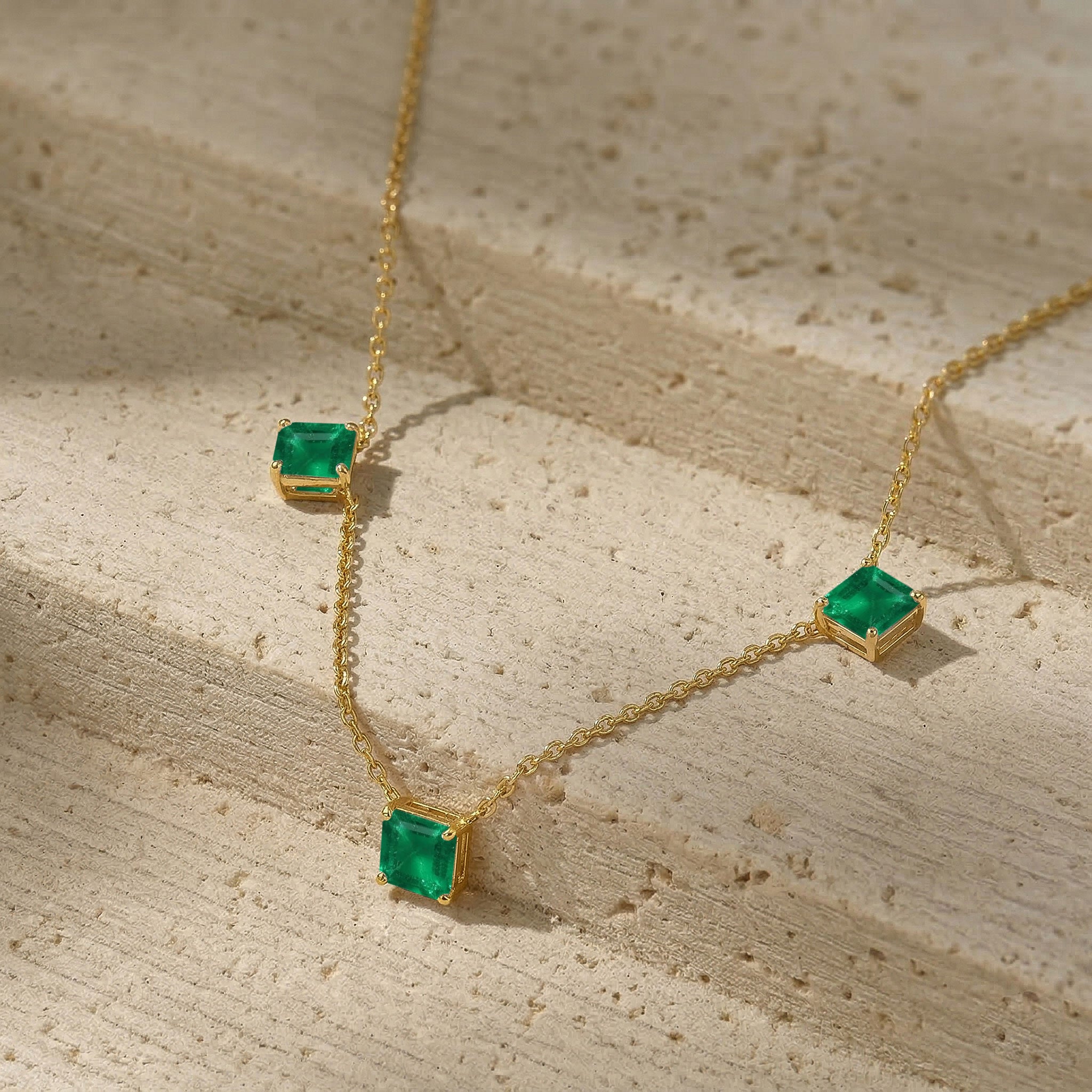Luxury Emerald gemstone necklace featuring three Asscher cut green stones.
