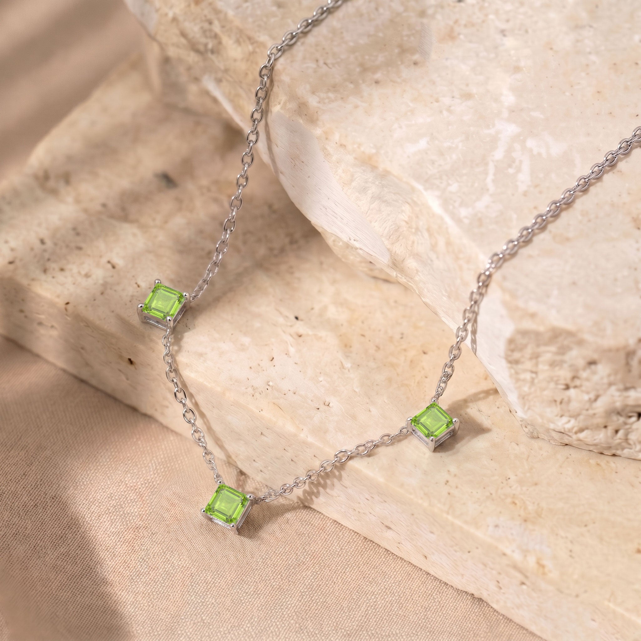 Dainty Peridot gemstone necklace with three Asscher cut stones and yellow gold filled finish.
