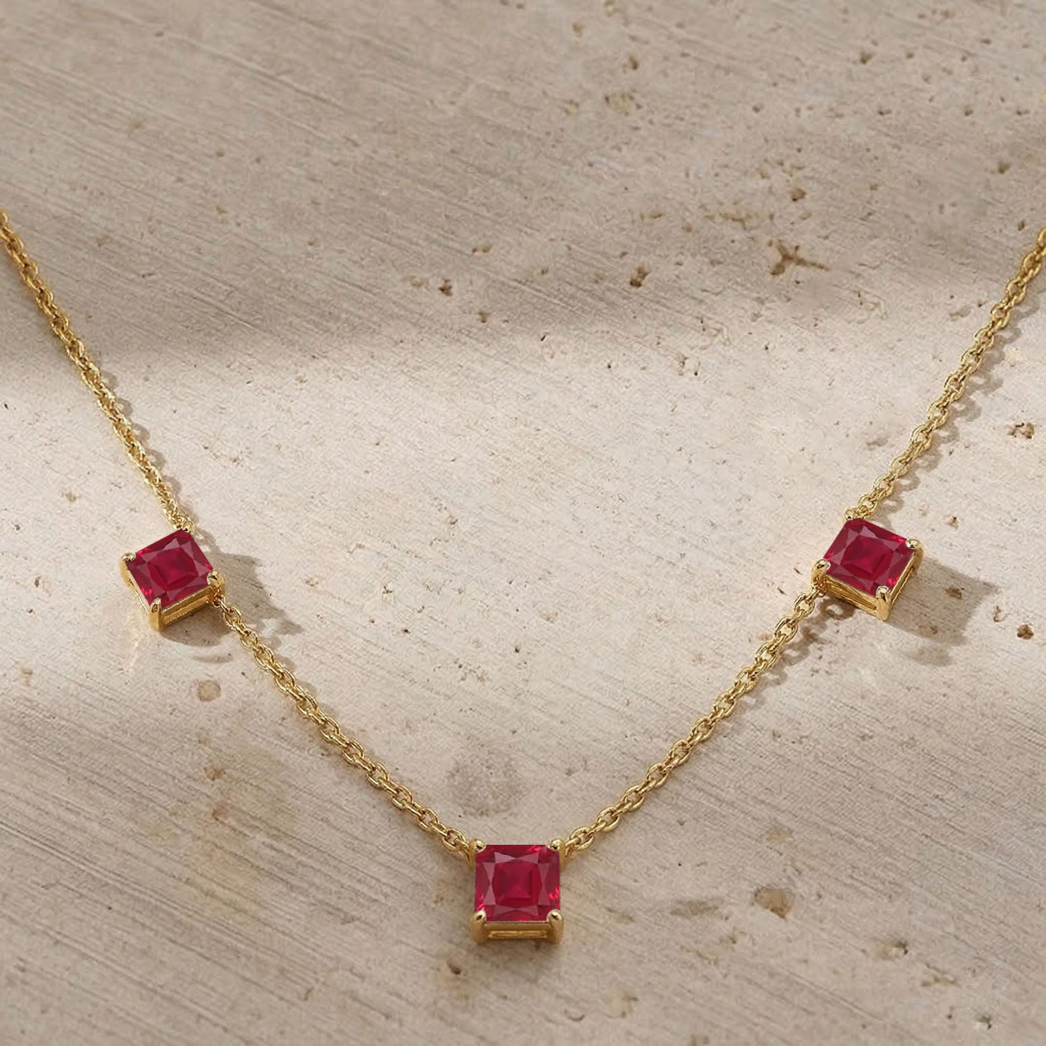 July birthstone Ruby necklace with elegant three stone design and fine jewelry craftsmanship.
