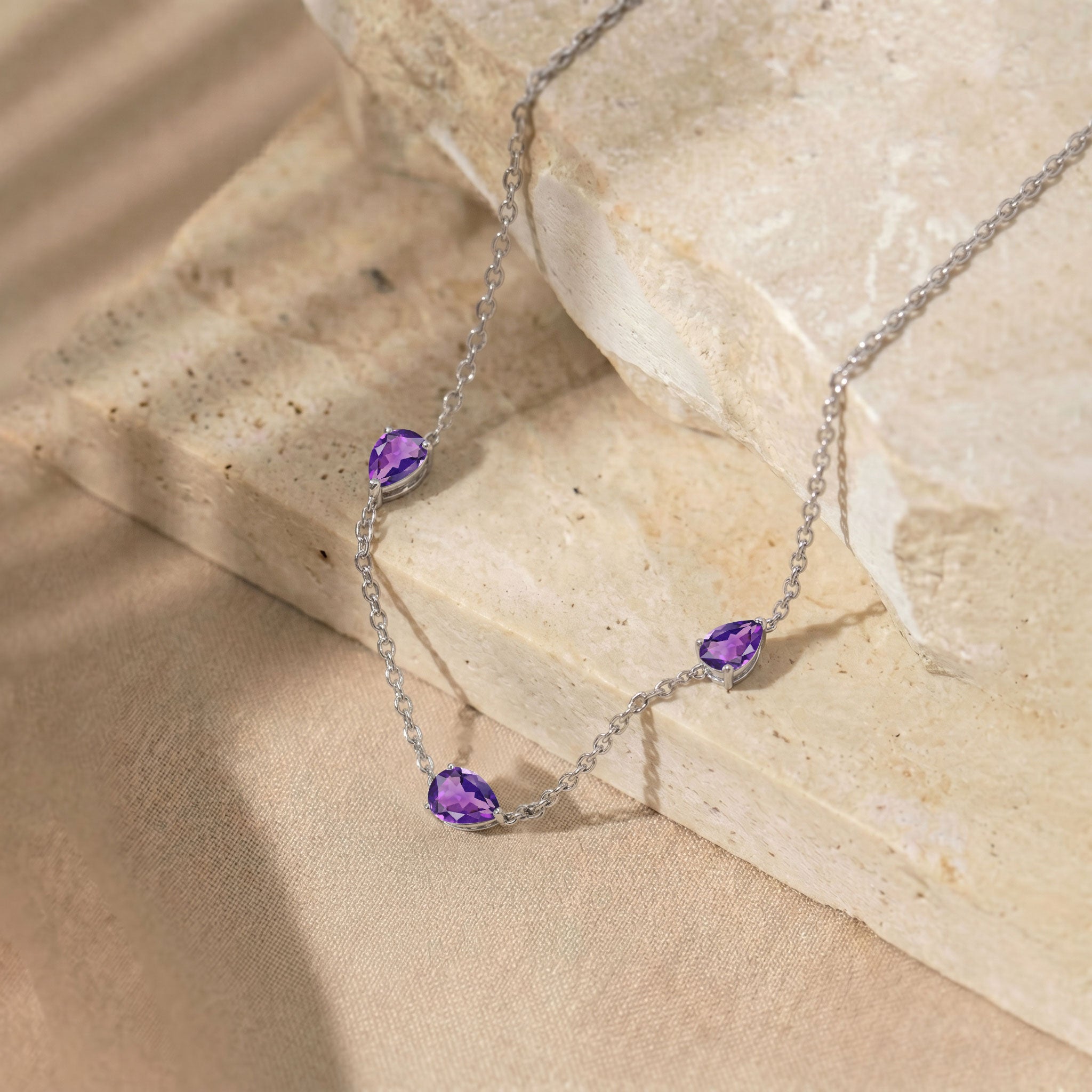Close-up of genuine pear cut Amethyst gemstones on necklace.
