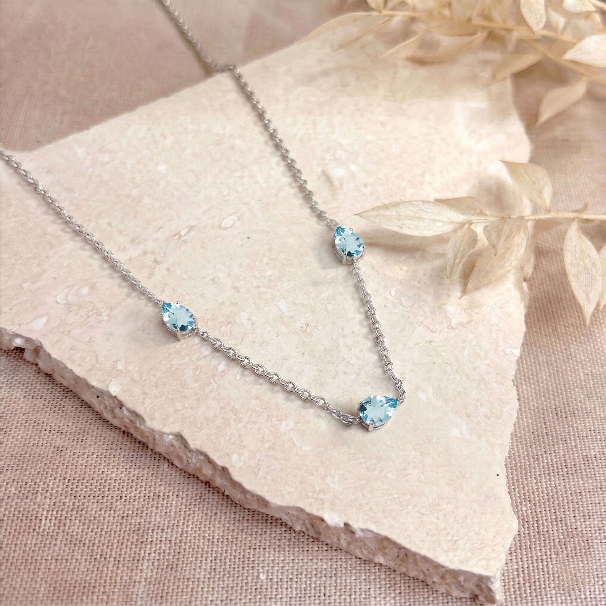 Close up of pear cut Aquamarine gemstones on gold filled necklace
