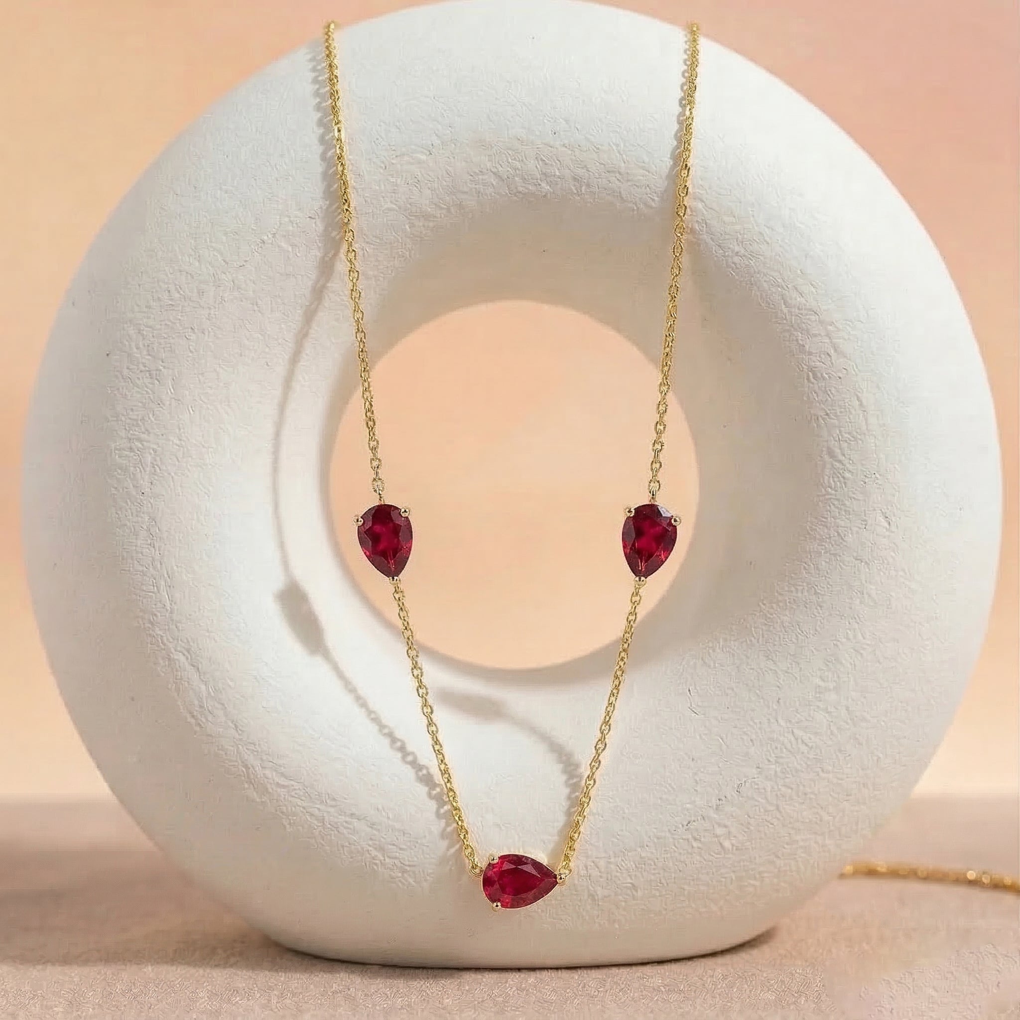 Luxury ruby pear cut pendant necklace with vibrant red gemstones and delicate sterling silver chain design
