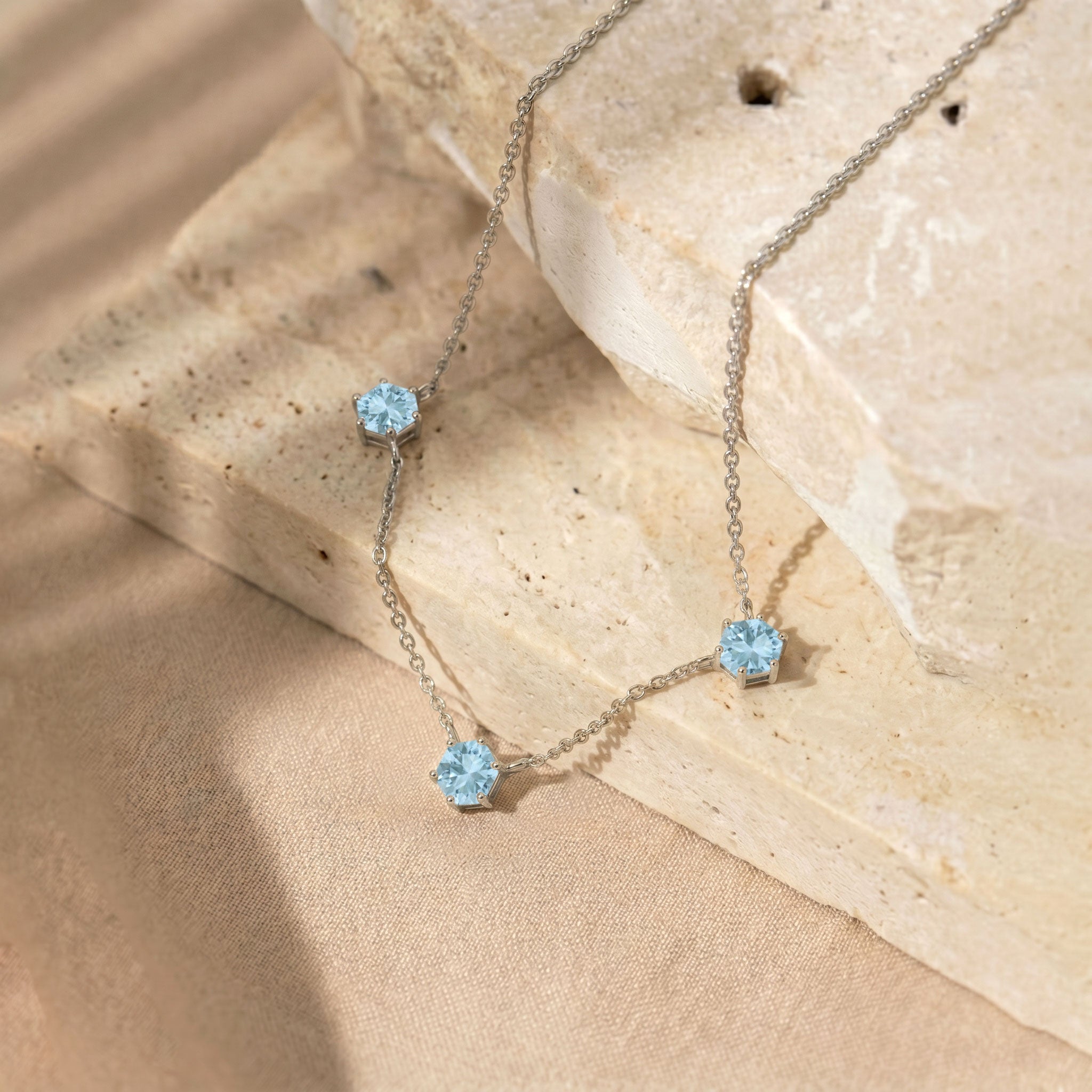 Aquamarine hexagon necklace in 925 sterling silver with three blue gemstones, perfect for women who love minimalist fine gemstone jewelry.
