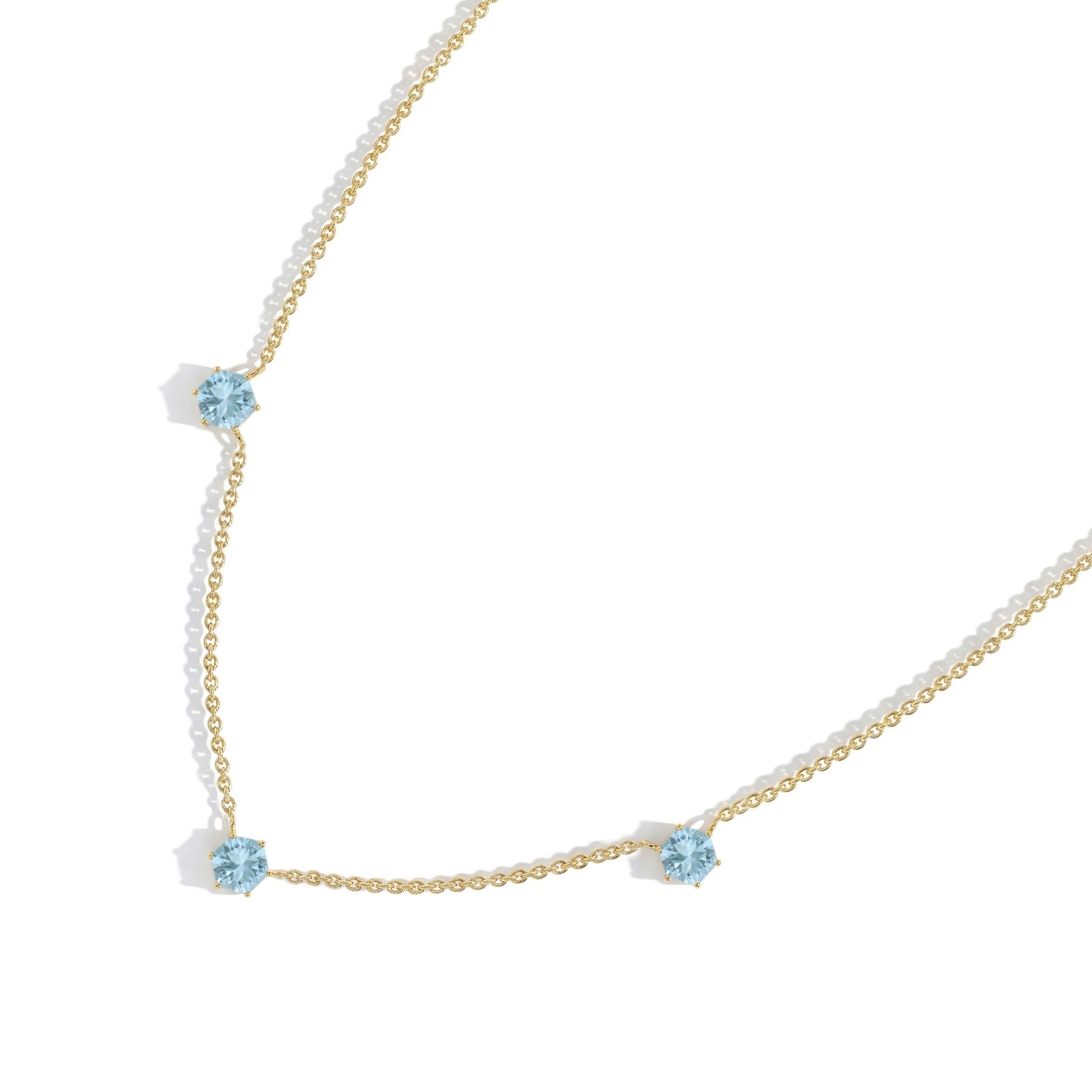Minimalist blue gemstone station necklace featuring Aquamarine stones, sterling silver craftsmanship, and modern jewelry styling.
