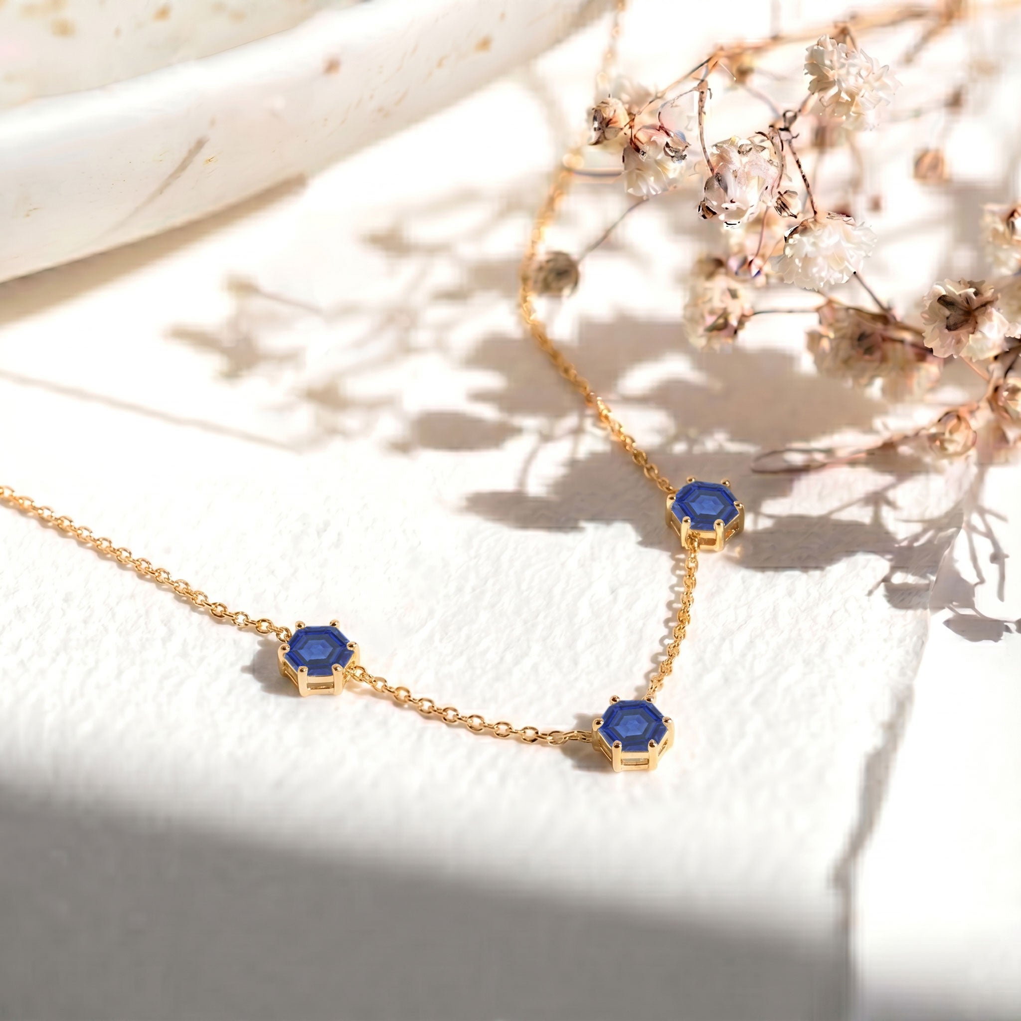 Blue sapphire gemstone necklace for women with three stone hexagon cut jewelry details
