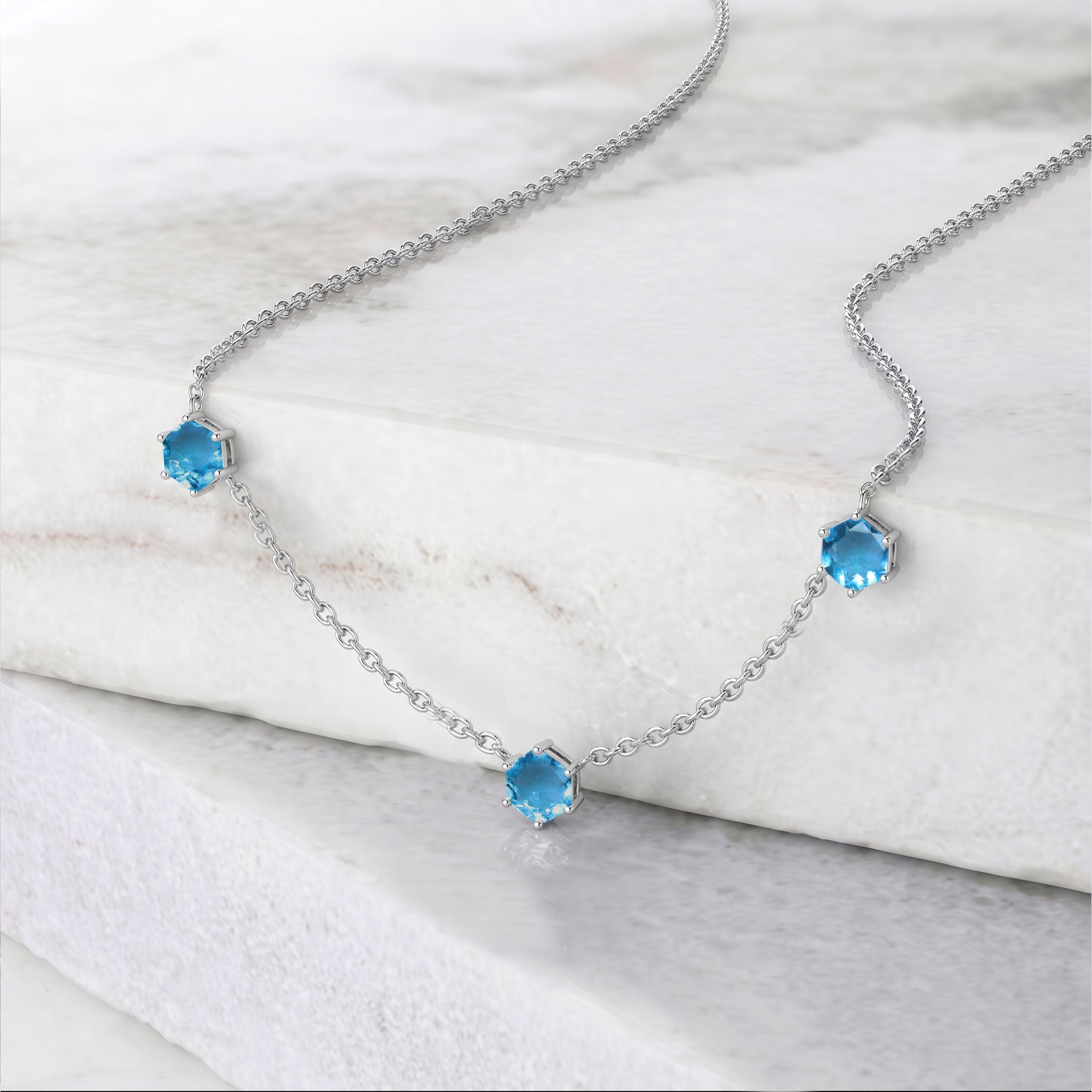 Blue topaz station necklace with three 6mm hexagon cut gemstones and adjustable silver chain
