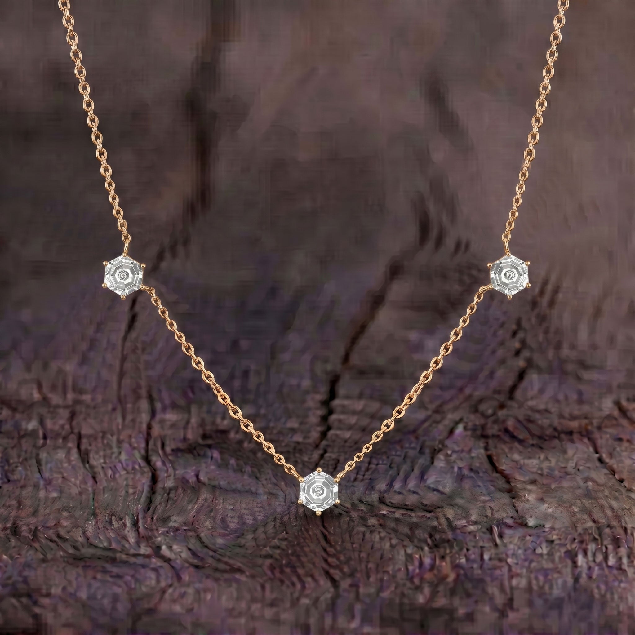 Close up view of three hexagon cut moissanite stones on necklace design

