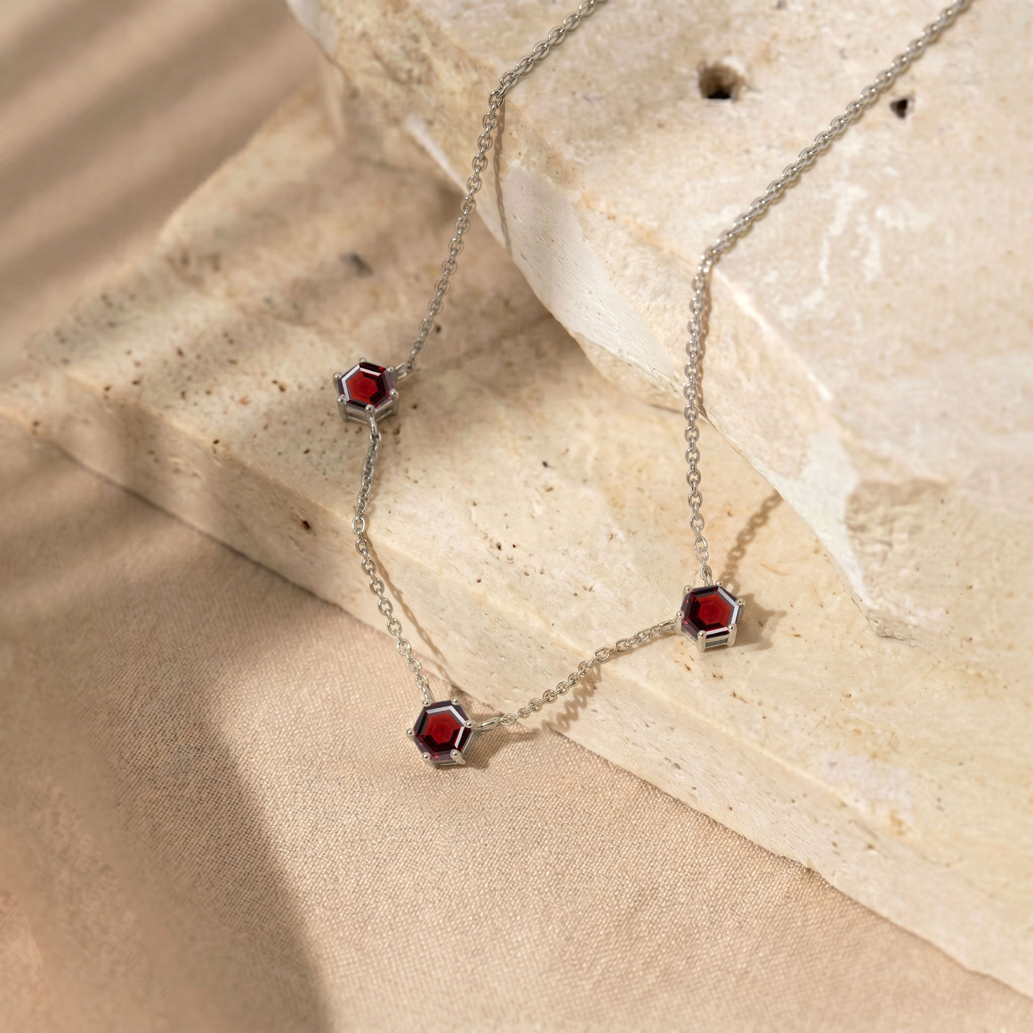 Luxury garnet station necklace featuring geometric gemstone accents and fine jewelry design
