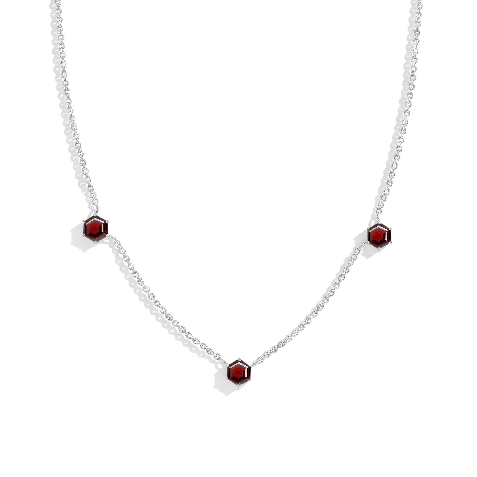 "Three stone garnet station necklace featuring hexagon cut gemstones in sterling silver jewelry design
