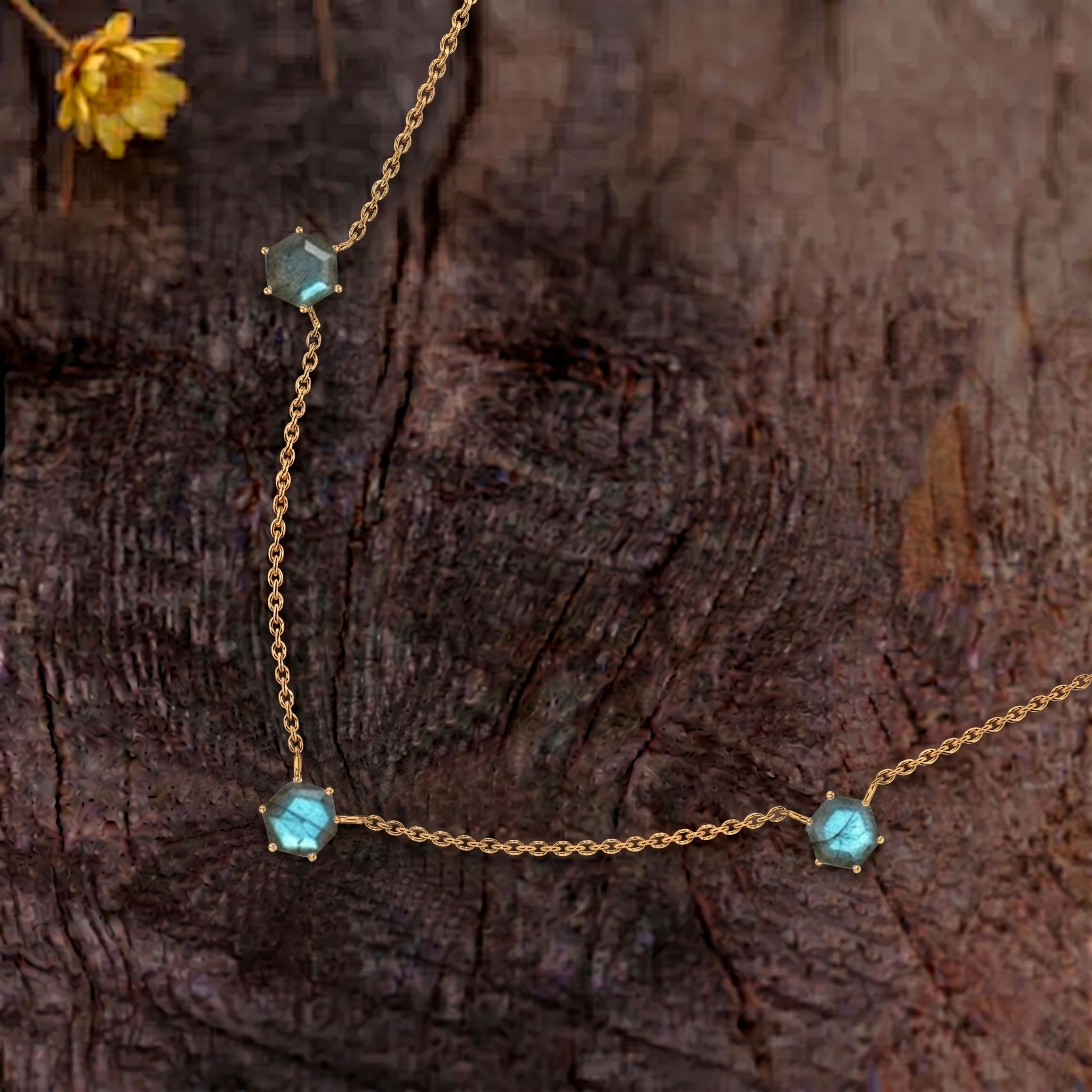 Close up view of three hexagon cut labradorite gemstones on necklace design
