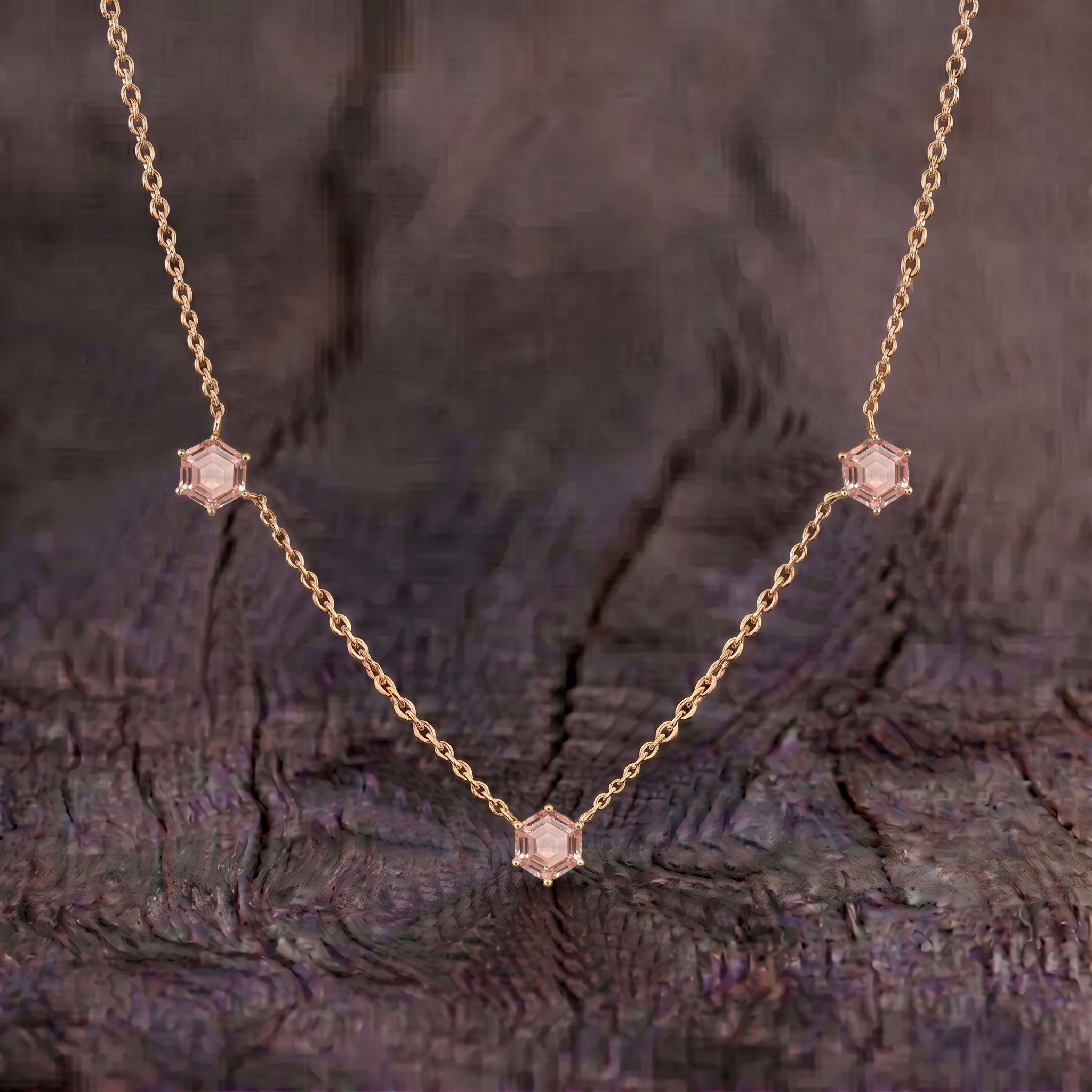 Close up view of three hexagon cut morganite gemstones on elegant necklace design
