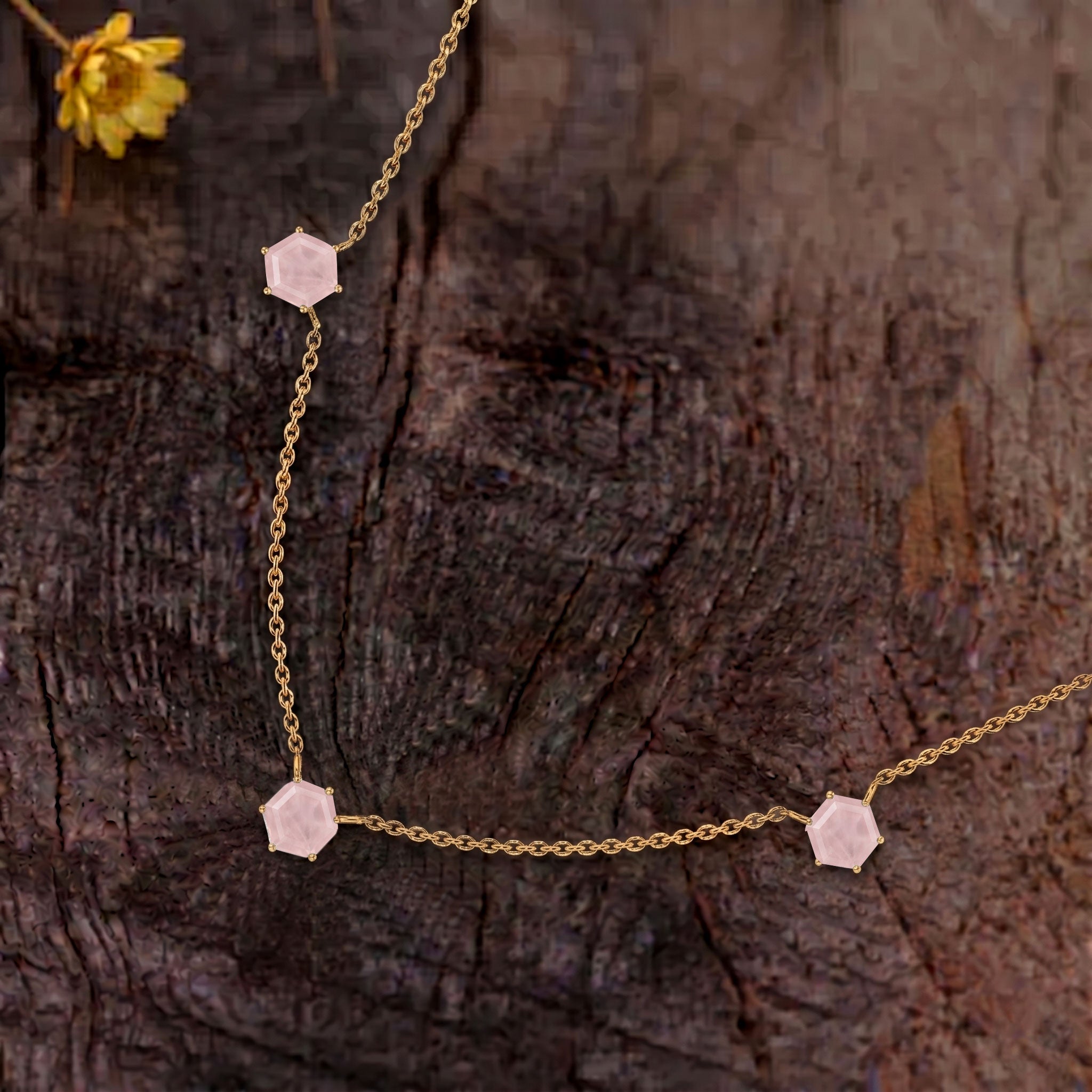 Close up view of three hexagon cut rose quartz gemstones on necklace design
