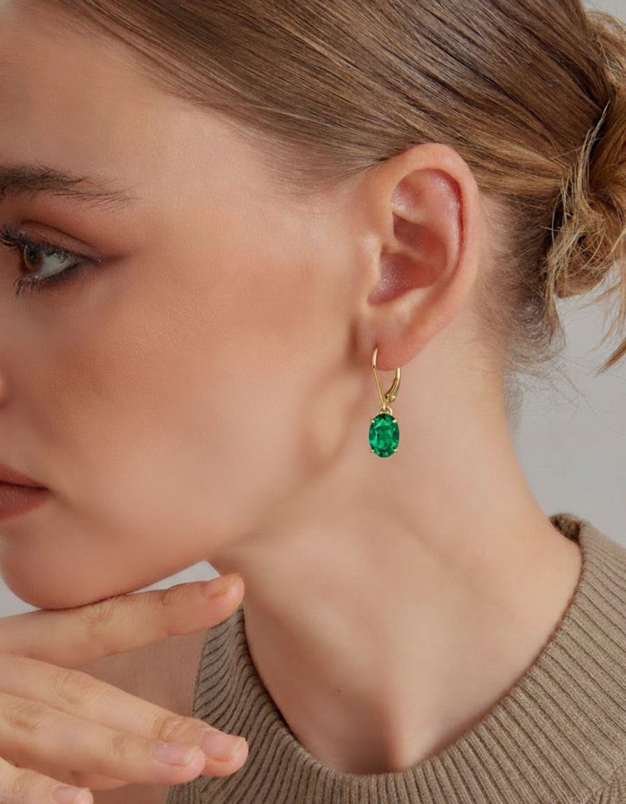 14K gold plated oval emerald dangle drop earrings featuring twin AAA lab green gemstones in an elegant leverback style.