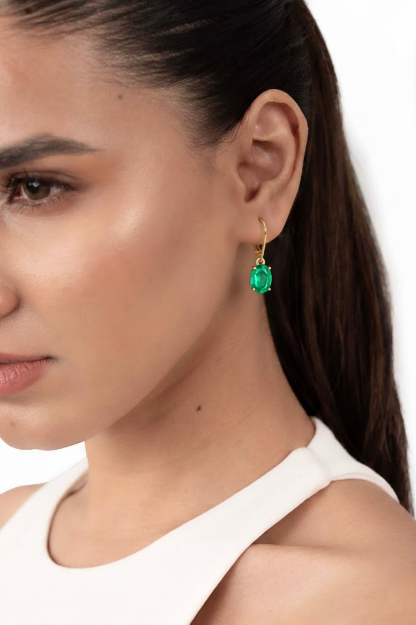 Front view of dainty 8x6mm oval cut emerald drop earrings with secure gold plated brass closures.