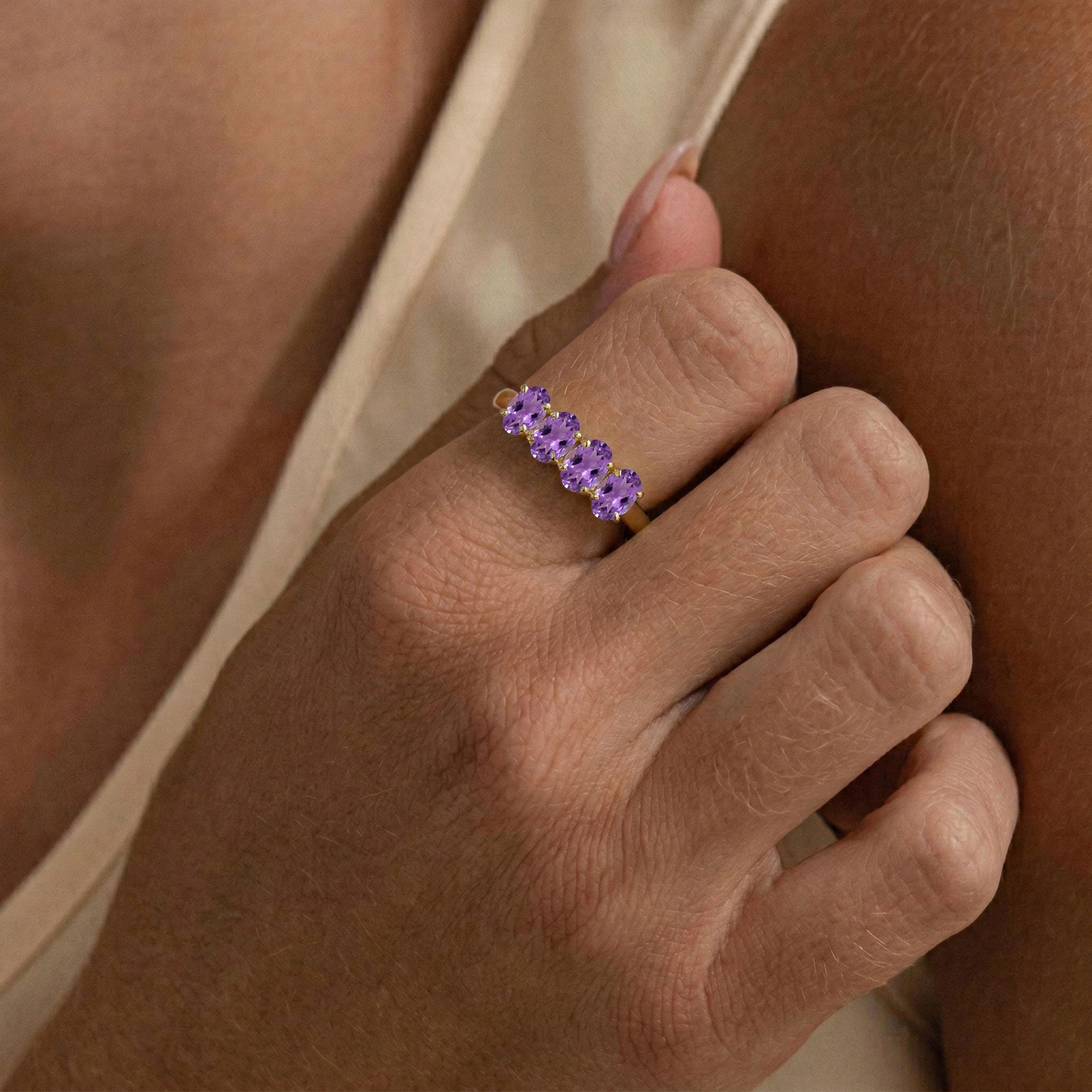 February birthstone jewelry, vibrant purple gemstone ring, handcrafted women's accessory, oval faceted gemstones, luxury gemstone fashion, classic four stone design, elegant ring collection, refined jewelry craftsmanship, premium gemstone band, timeless beauty