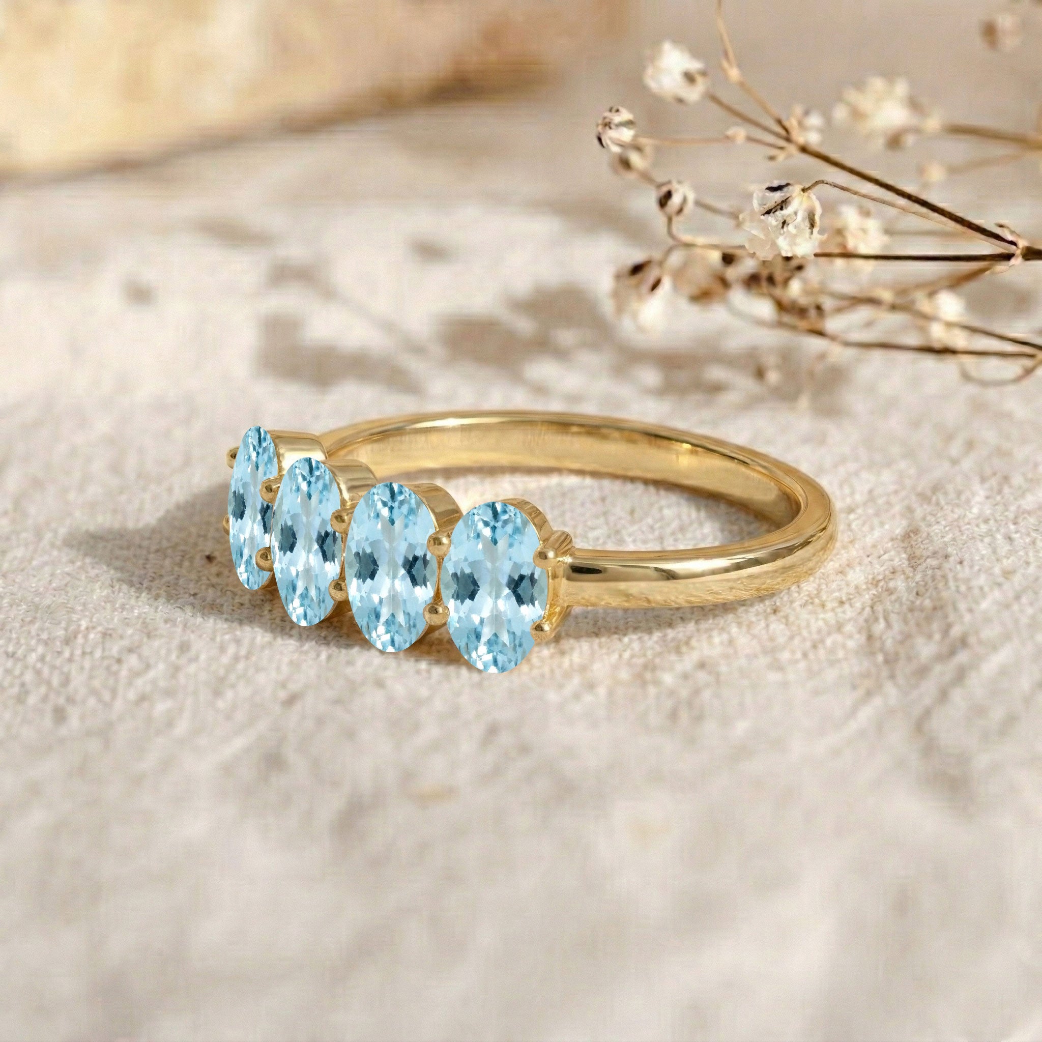blue gemstone ring, four aquamarine stones, oval faceted gemstones, sterling silver jewelry, elegant women's ring, classic gemstone band, March birthstone gift, luxury accessory, delicate stackable ring, artisan jewelry, timeless fashion, gift idea