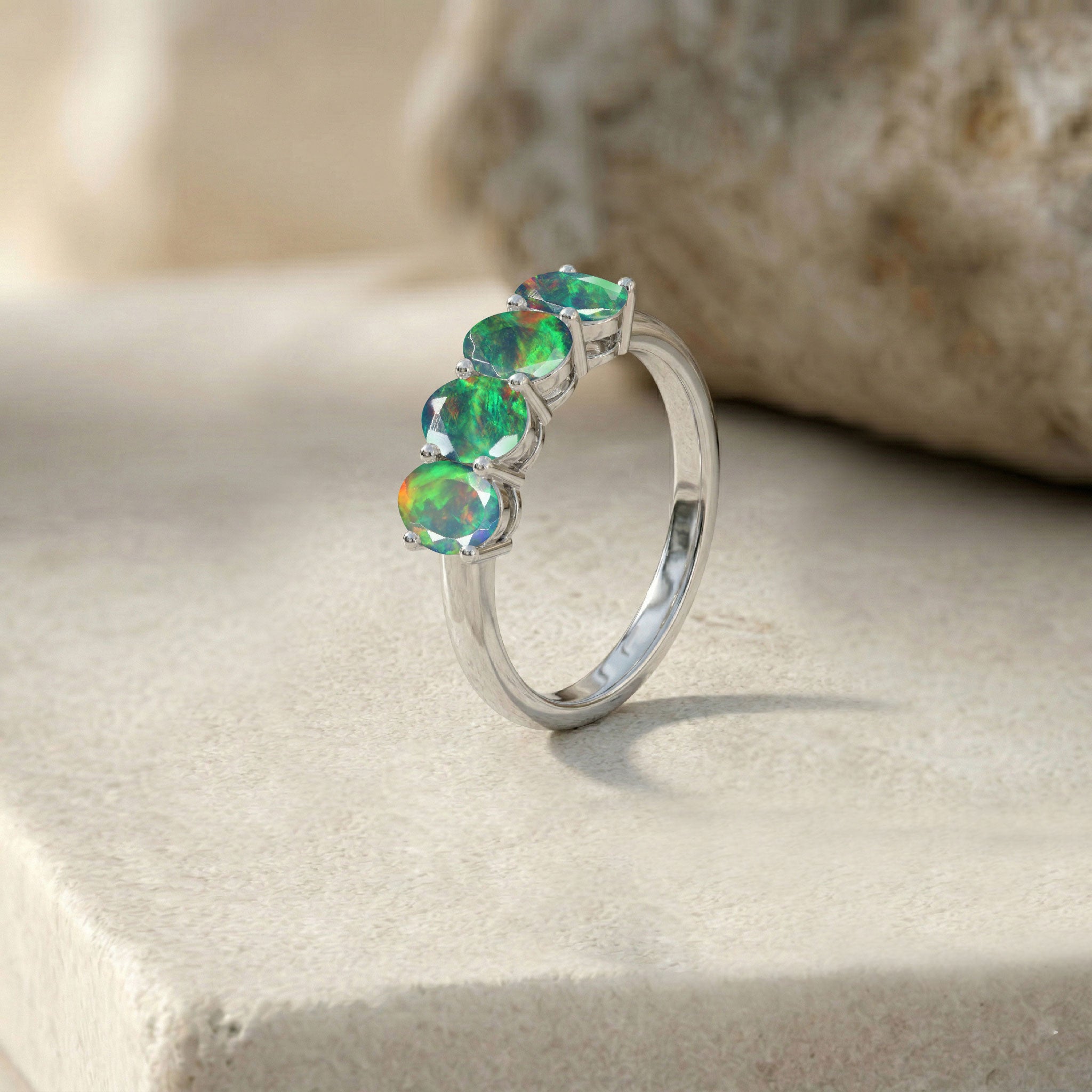 natural black opal fine ring, luxury gemstone accessory, colorful oval opals, handcrafted artisan jewelry, premium four stone design, elegant stacking band, October gemstone keepsake, refined fashion ring, polished metal craftsmanship, contemporary women's jewelry, unique anniversary gift, brilliant gemstone sparkle